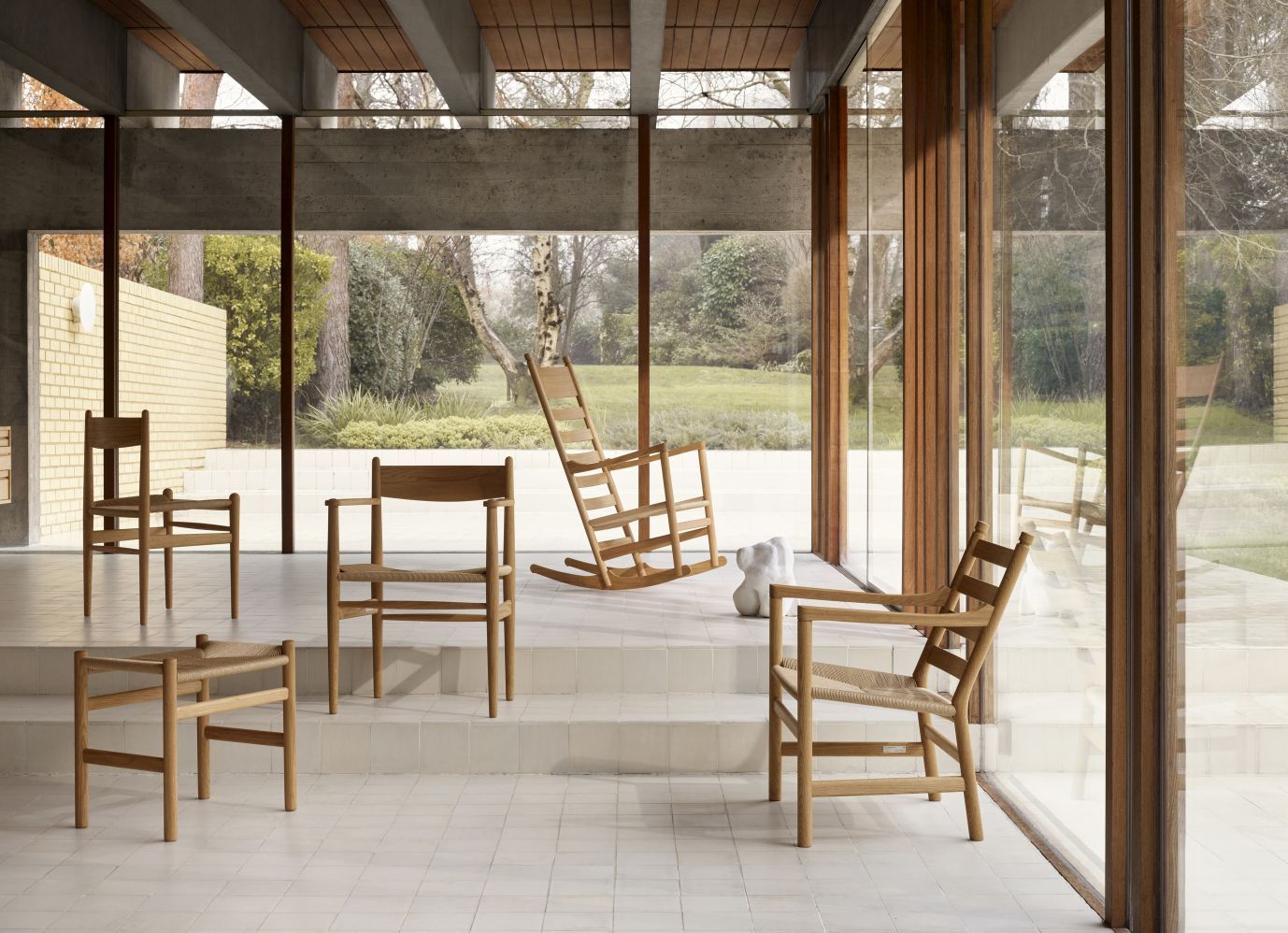CH45 Schaukelstuhl von Carl Hansen & Søn in heller, moderner Inneneinrichtung mit weiteren Holzstühlen.
