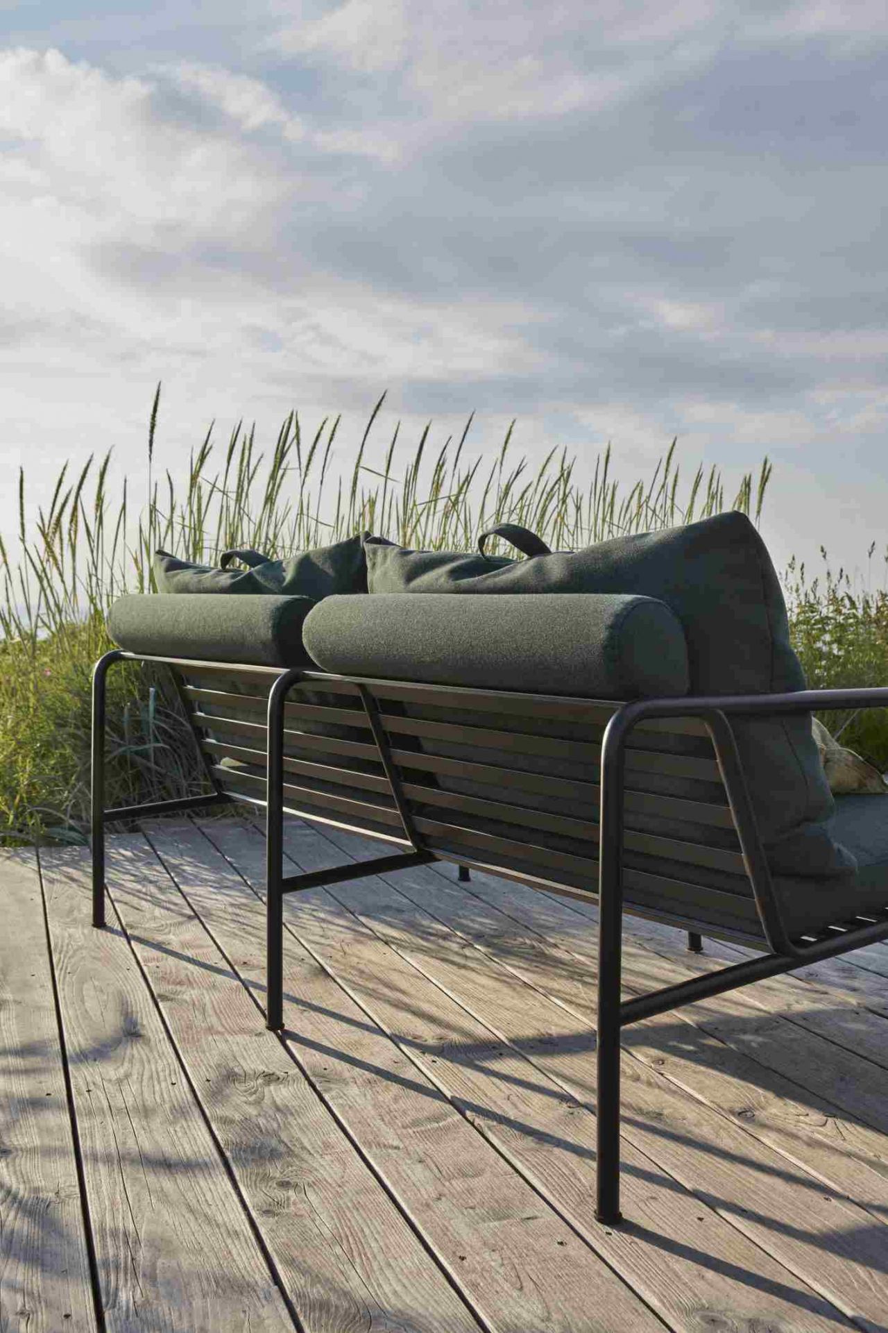 Avon 2-Sitzer Sofa von Houe für den Außenbereich mit grünen Kissen auf Holzterrasse.