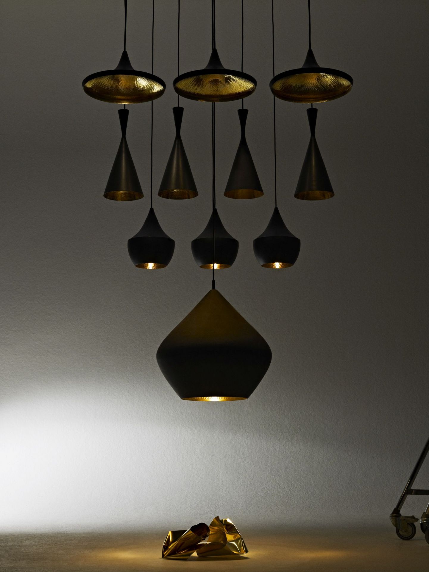 Nahaufnahme der Tom Dixon Beat Pendelleuchten in Schwarz und Gold, modernes Designelement.