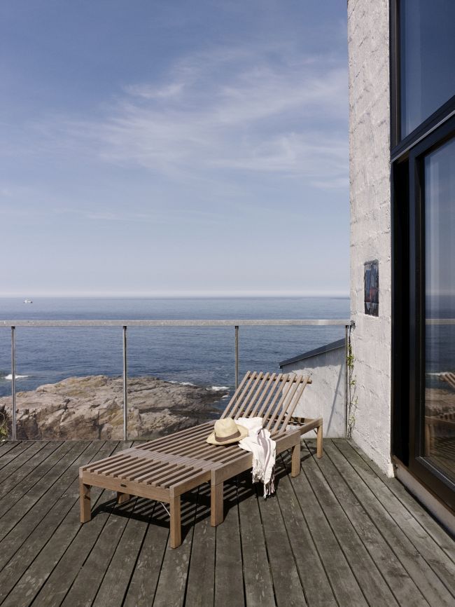 Riviera Sonnenliege aus Holz auf Terrasse mit Meerblick. Outdoor Liege für Garten und Balkon.