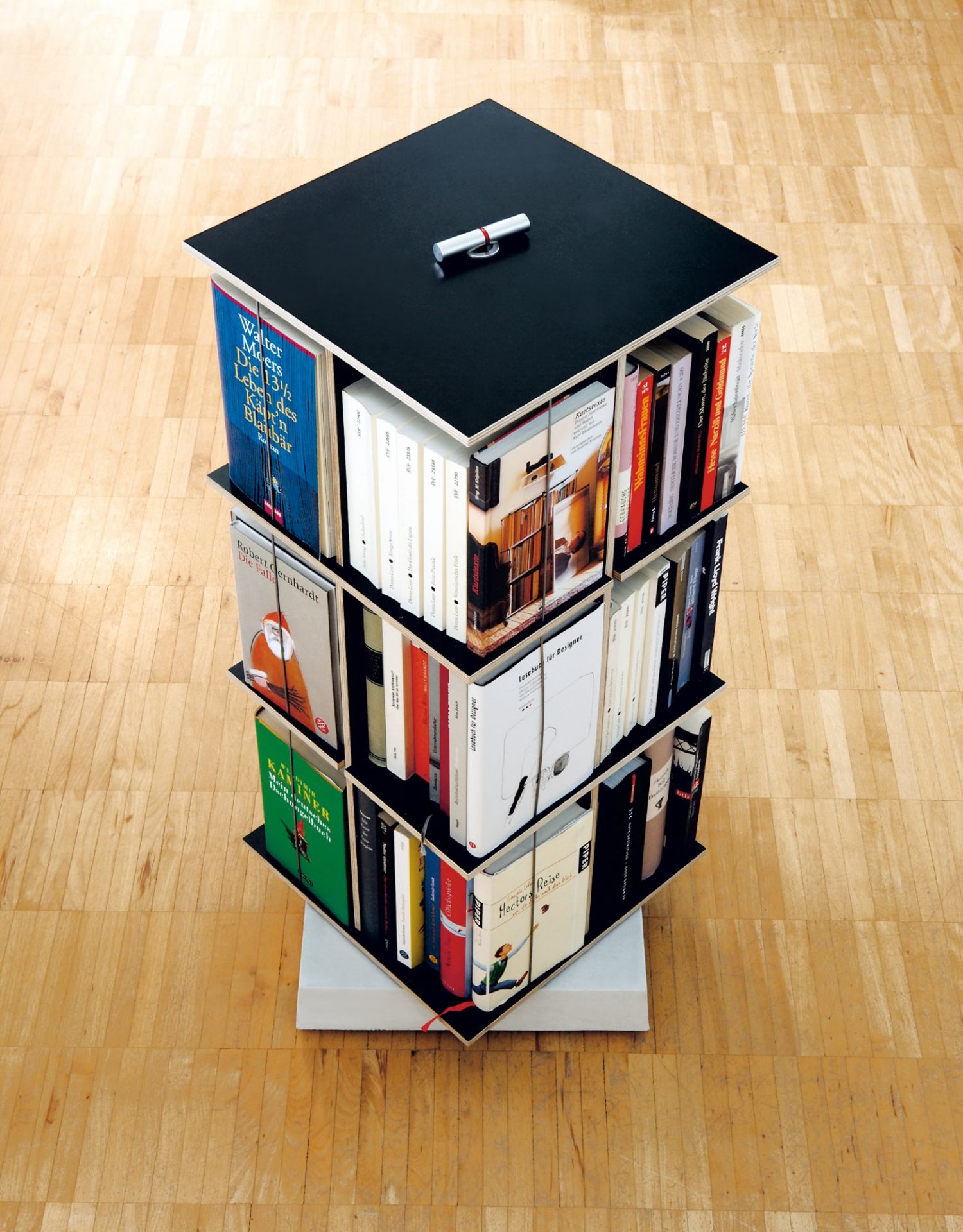 Buchstabler Bücherturm von Moormann: Dreistöckiges, modernes Bücherregal mit schwarzen Böden und vielen Büchern.