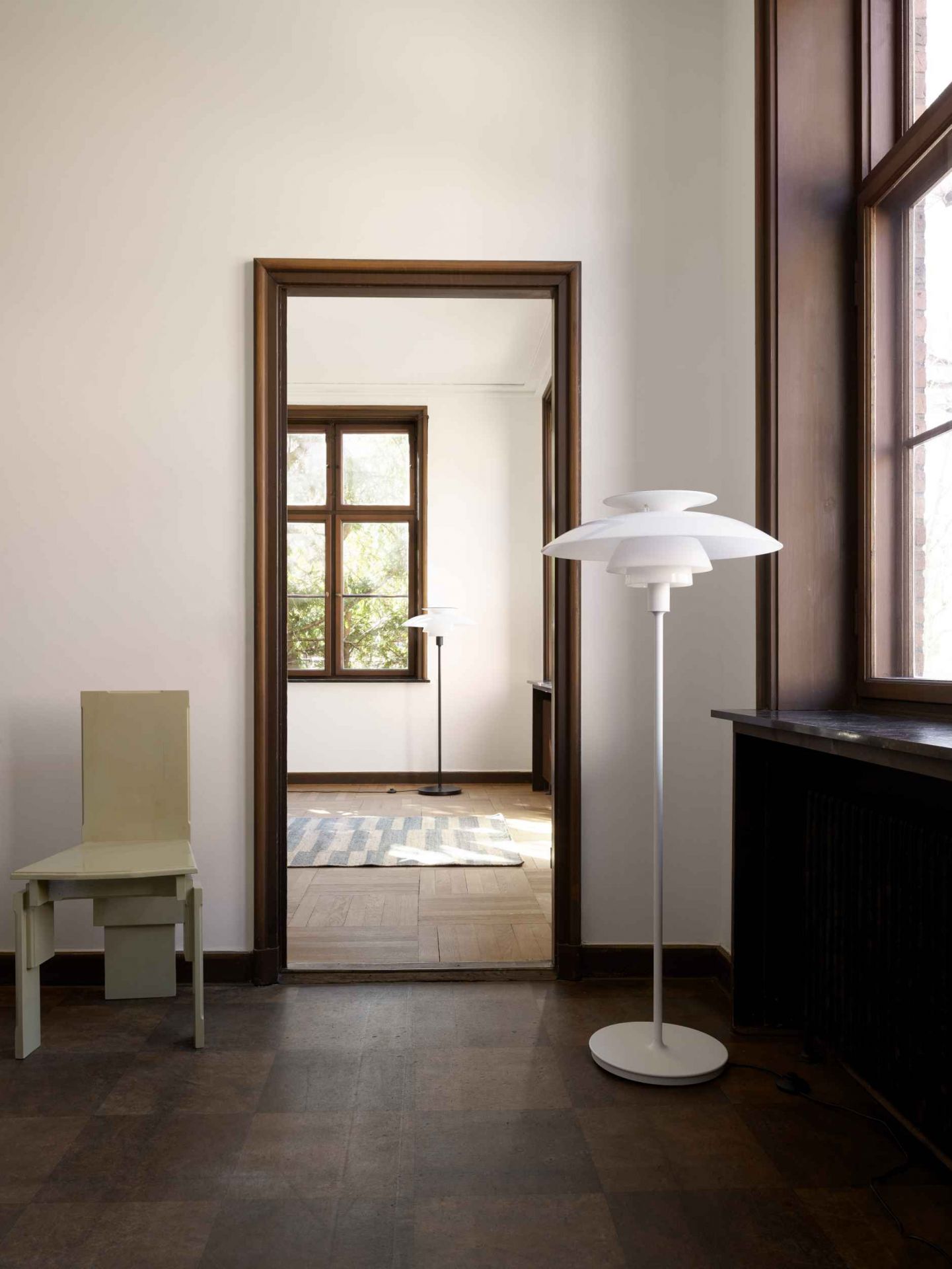 Weiße PH 80 Stehleuchte von Louis Poulsen im Interieur mit Türrahmen und Fenster.