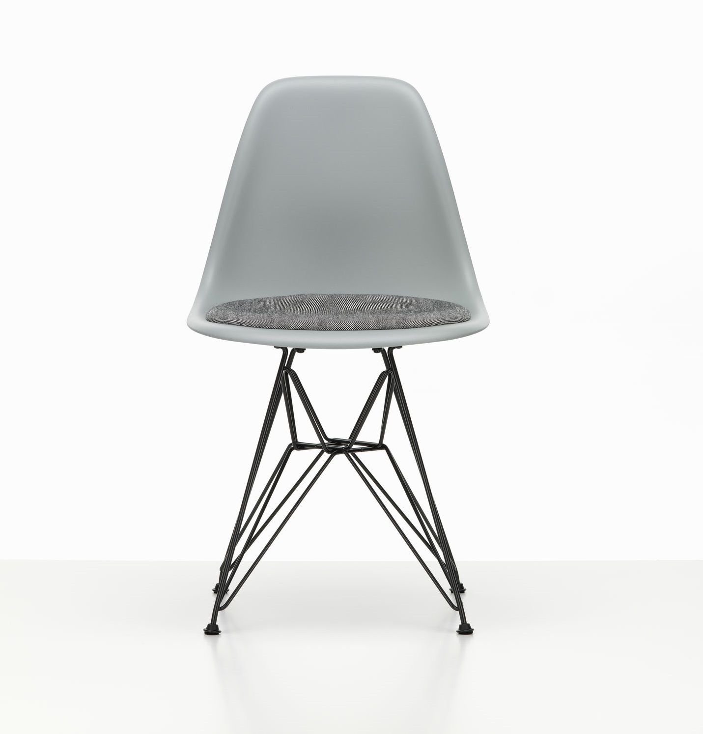 Grauer Eames Plastic Side Chair DSR Stuhl mit Sitzpolster und schwarzem Eiffelturmgestell von Vitra.