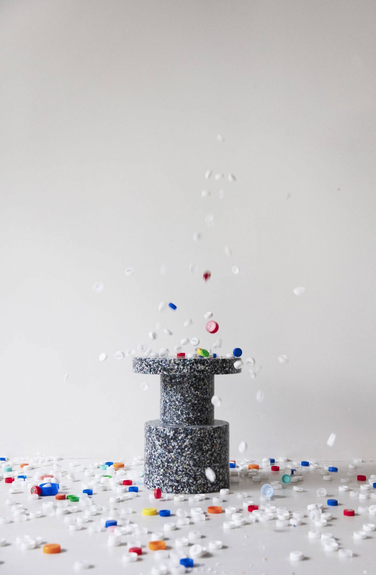 Normann Copenhagen Bit Stool Hocker aus recyceltem Kunststoff mit fallenden bunten Plastikdeckeln.