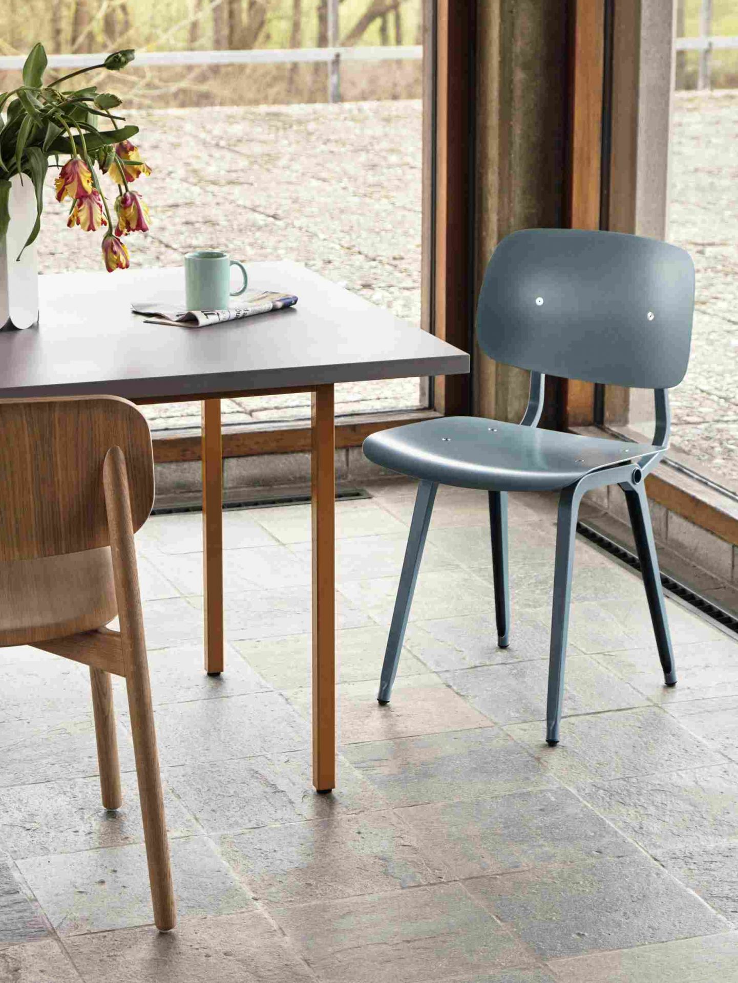 Nahaufnahme eines Esstisches mit Hay Stuhl in blau, modernes Möbeldesign für Esszimmer.