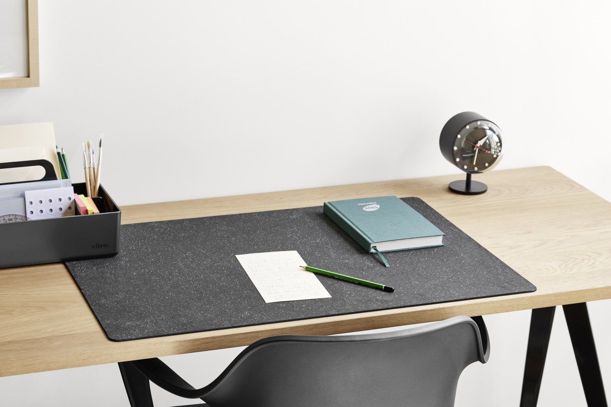 Schreibtisch mit Vitra Night Clock Tischuhr in Schwarz, Notizbuch, Stift und Schreibtischunterlage für Büroorganisation.