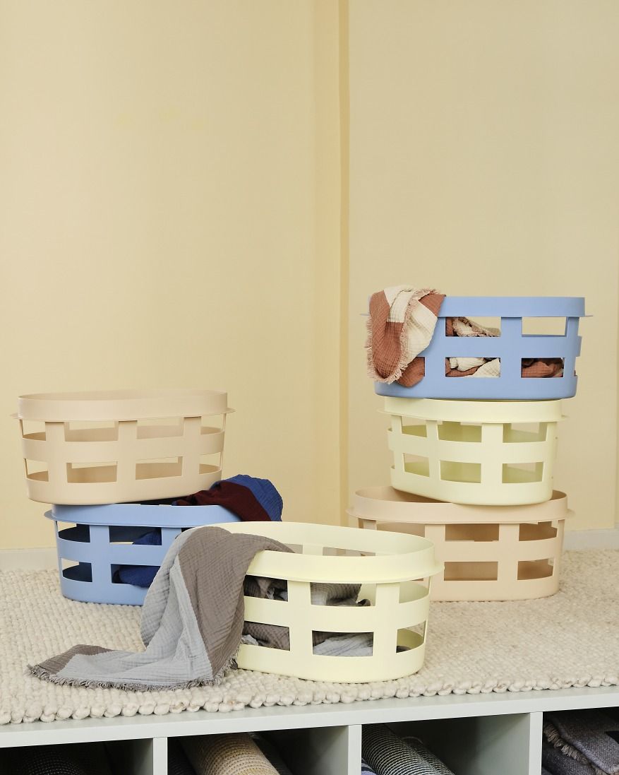 Mehrere Hay Laundry Basket Wäschekörbe S RECYCLED in Soft Blau, Beige und Gelb gestapelt.