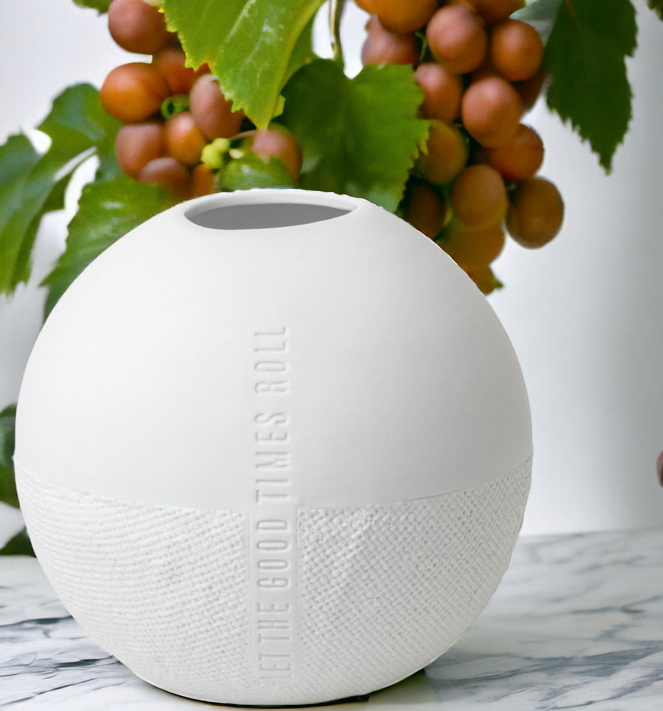 Formsprache Vase Let the Good Times Roll von Räder, weiße Keramikvase mit Textur und Trauben im Hintergrund.