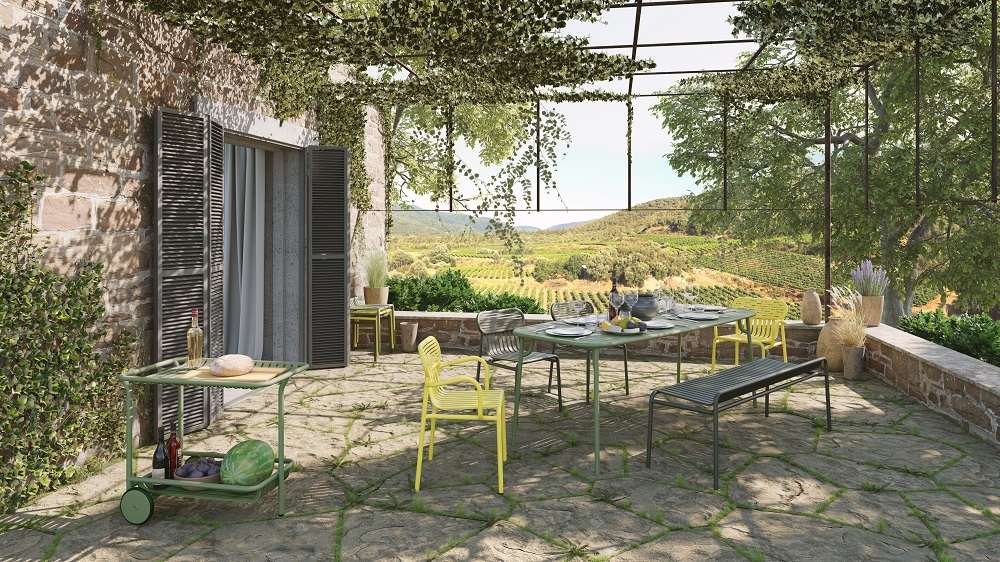 Petite Friture Week-End Gartenbank in Grün auf einer Terrasse mit Esstisch und malerischer Aussicht.
