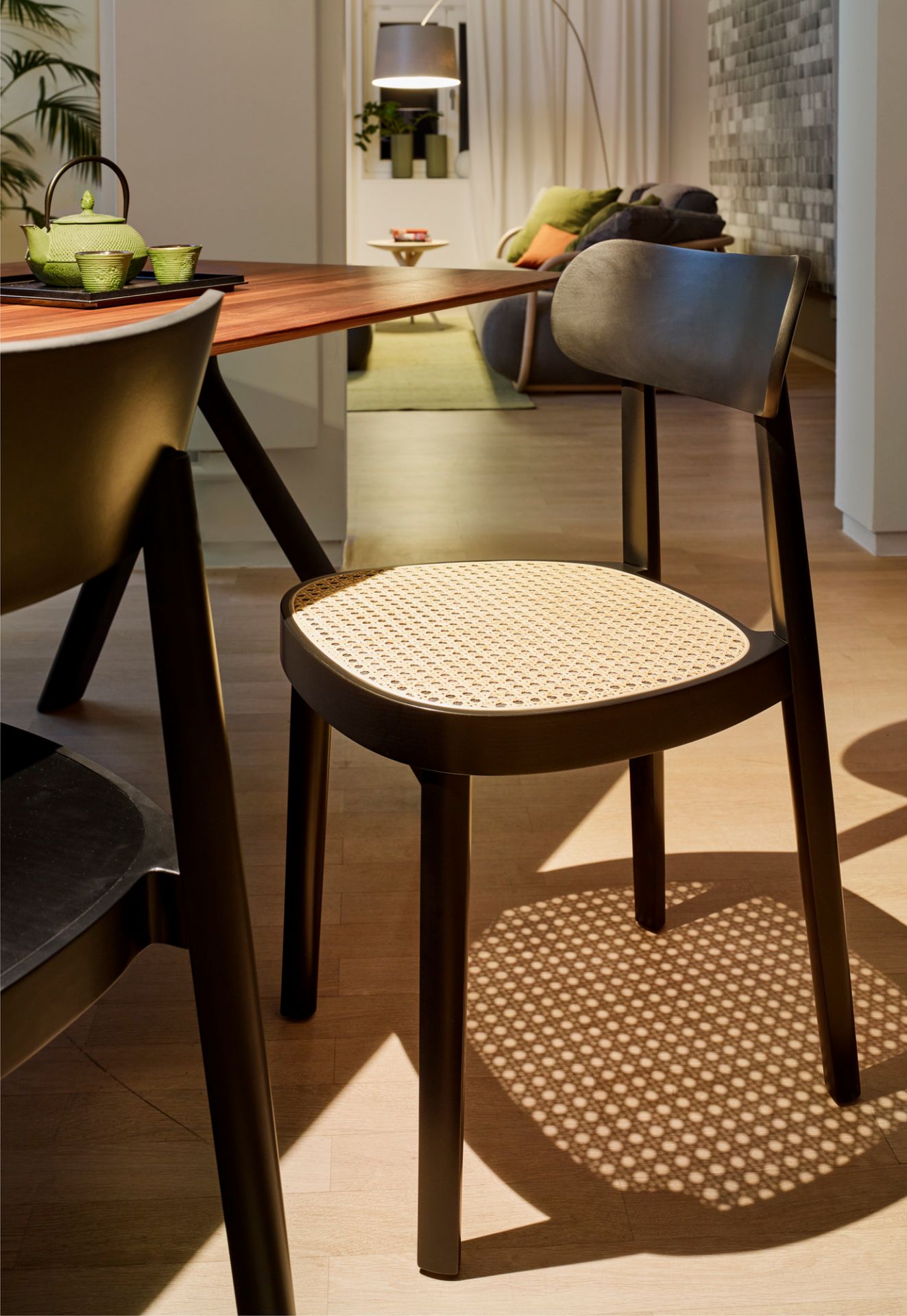 Schwarzer Holzstuhl mit Wiener Geflecht Sitzfläche, Modell 118 von Thonet, im modernen Esszimmer.