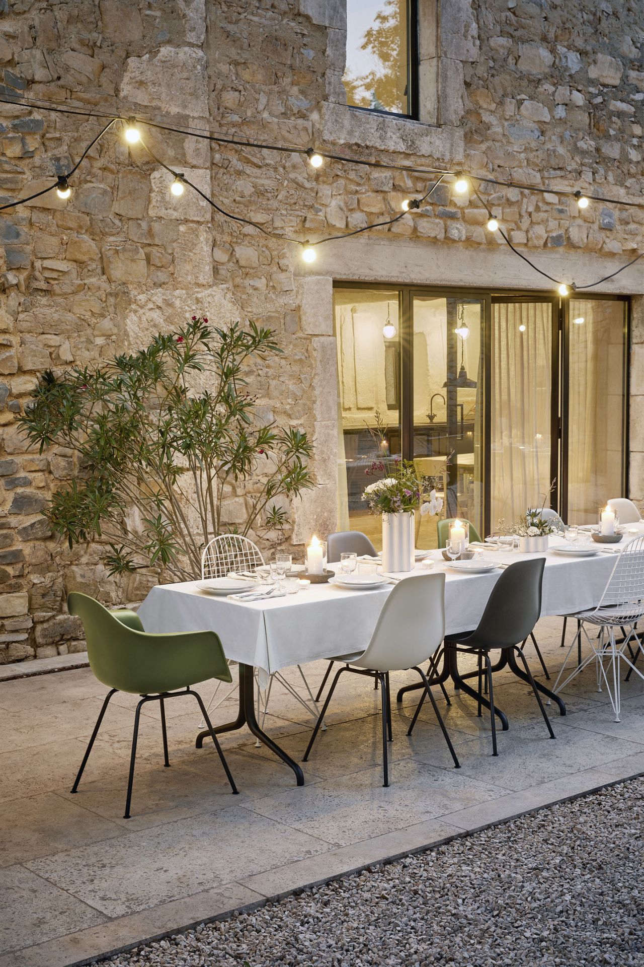 Esstisch im Freien mit Vitra Eames Plastic Arm Chairs DAX in verschiedenen Farben.