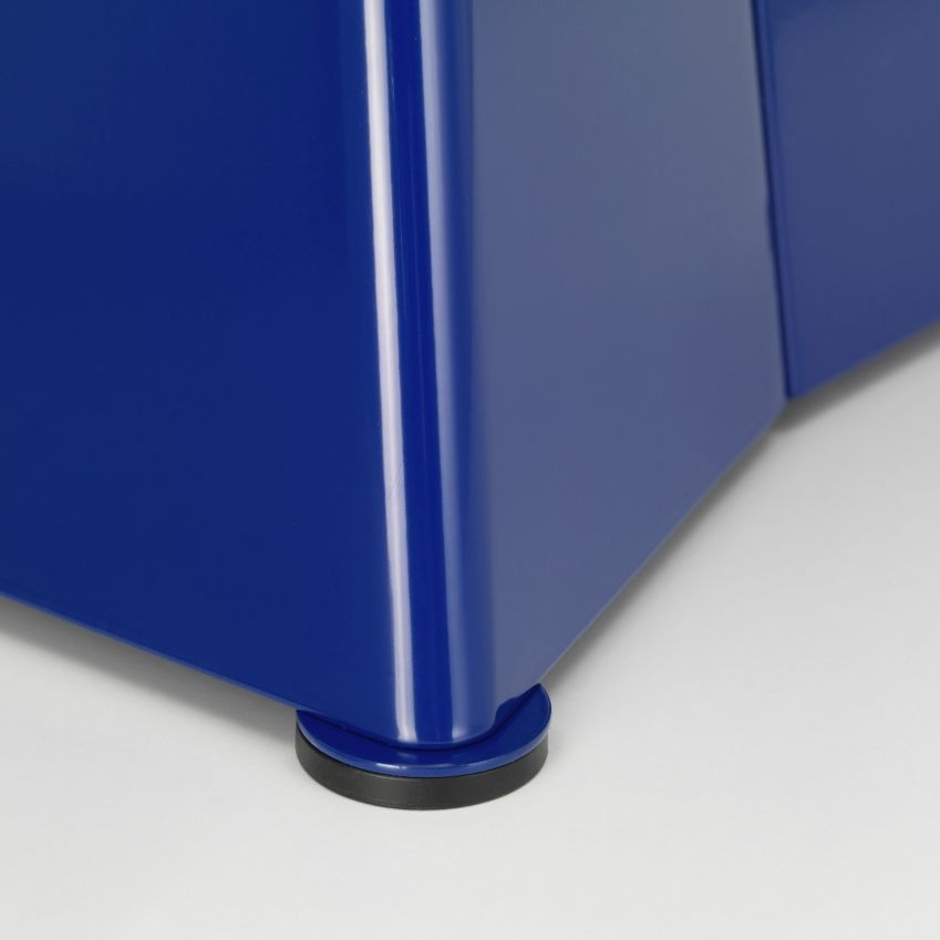 Detailaufnahme vom blauen Vitra Tabouret Métallique Hocker, der einen schwarzen Bodengleiter zeigt.
