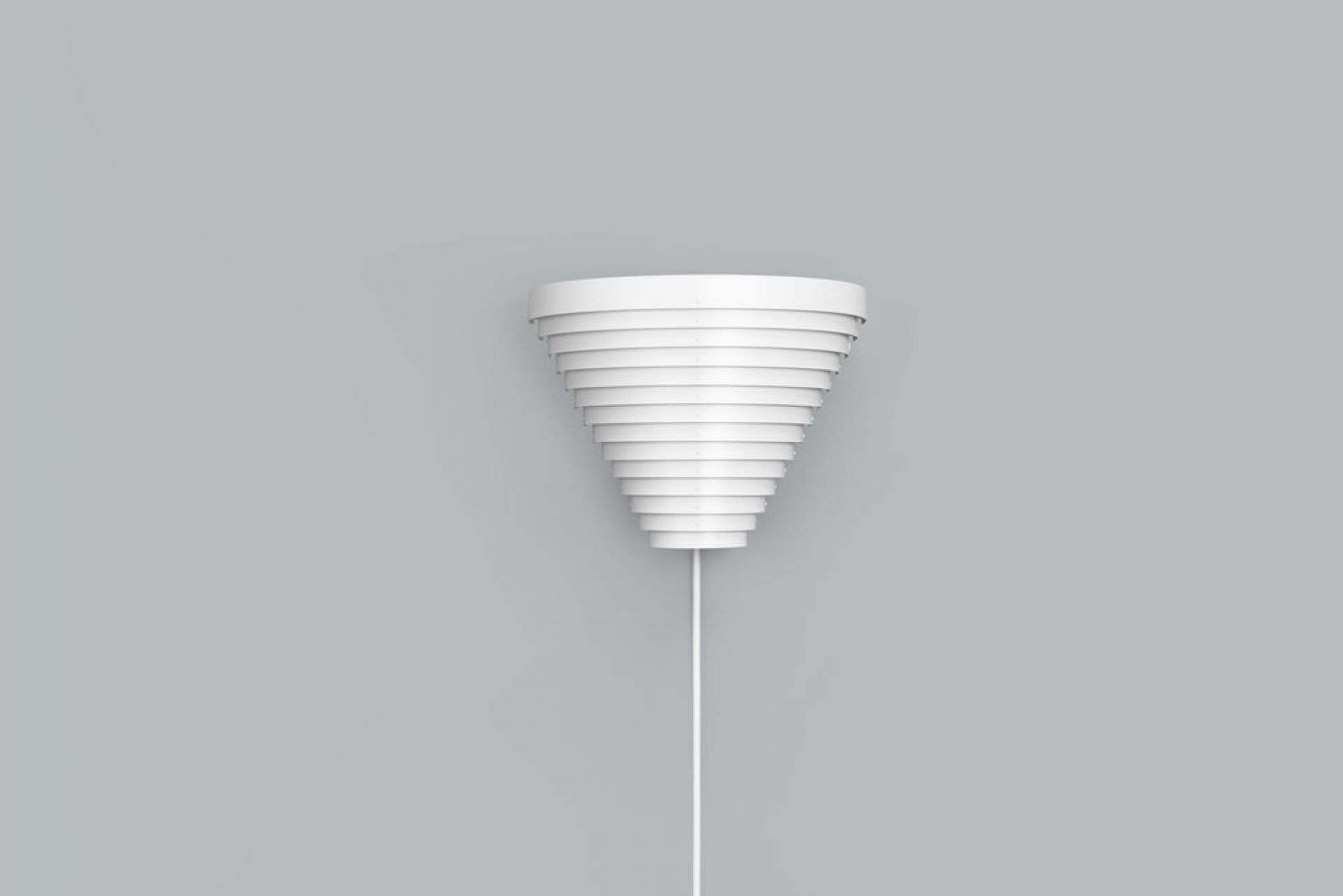Weiße A910 Wandleuchte von Artek mit konischem Lampenschirm und filigraner Aufhängung vor grauem Hintergrund.