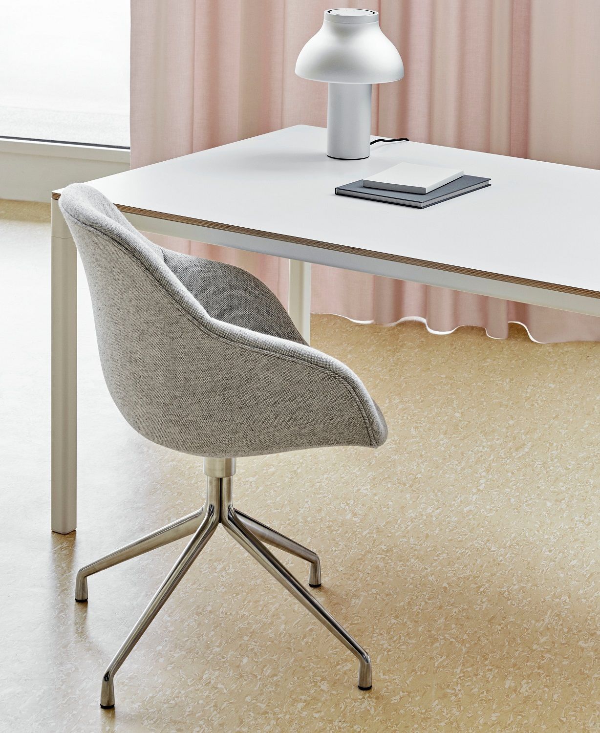 Grauer About a Chair AAC221 Stuhl von Hay mit Drehgestell und Schreibtisch im Hintergrund.