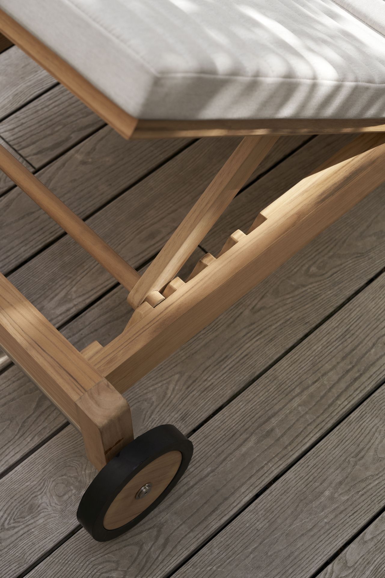 Detailaufnahme der Carl Hansen & Søn AH604 Teak Gartenliege mit Rad und Polster.
