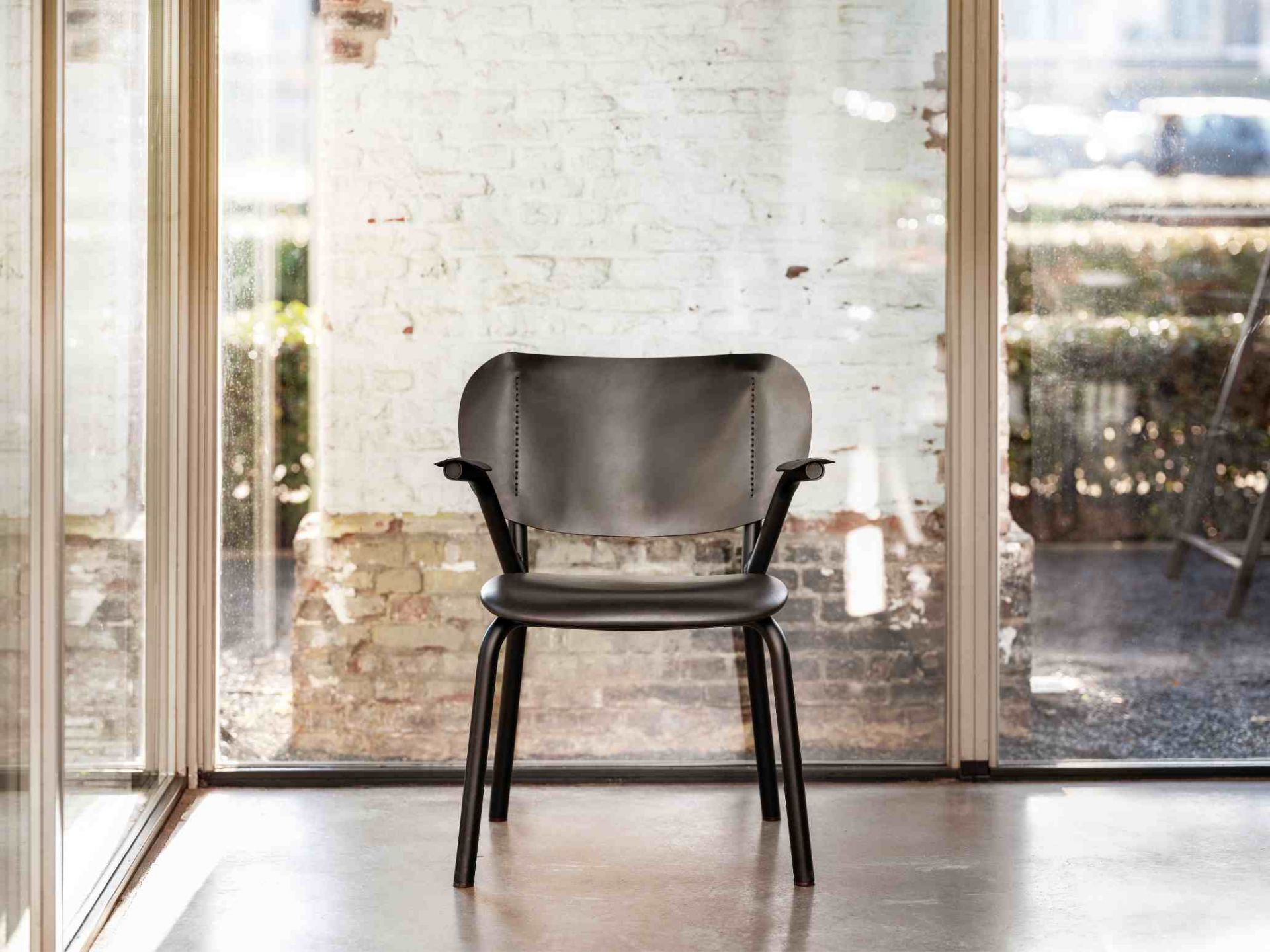 Emil Rosi Armchair Stuhl mit Armlehne von Functionals, moderner Designstuhl in Schwarz vor Fenster.