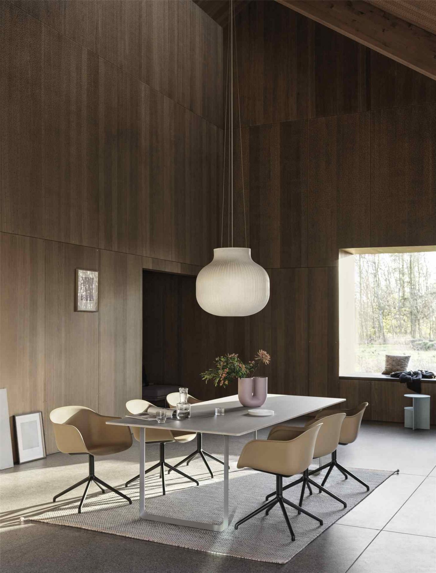 Esszimmer mit Muuto Kink Vase in Tiefrot auf grauem Tisch, moderne Dekoration und Design.