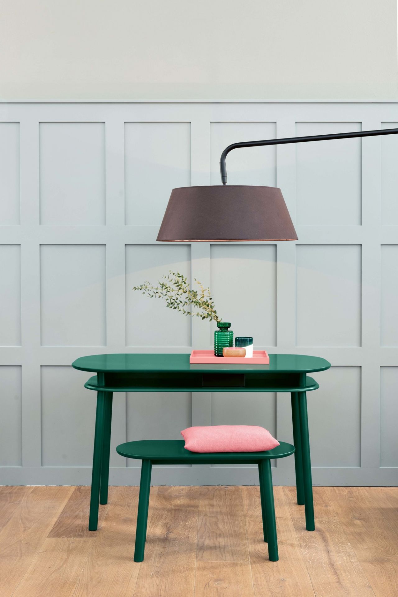 Mala Sitzbank von Schönbuch, grüne Holzbank mit rosa Kissen und passendem Tisch, modernes Möbeldesign.