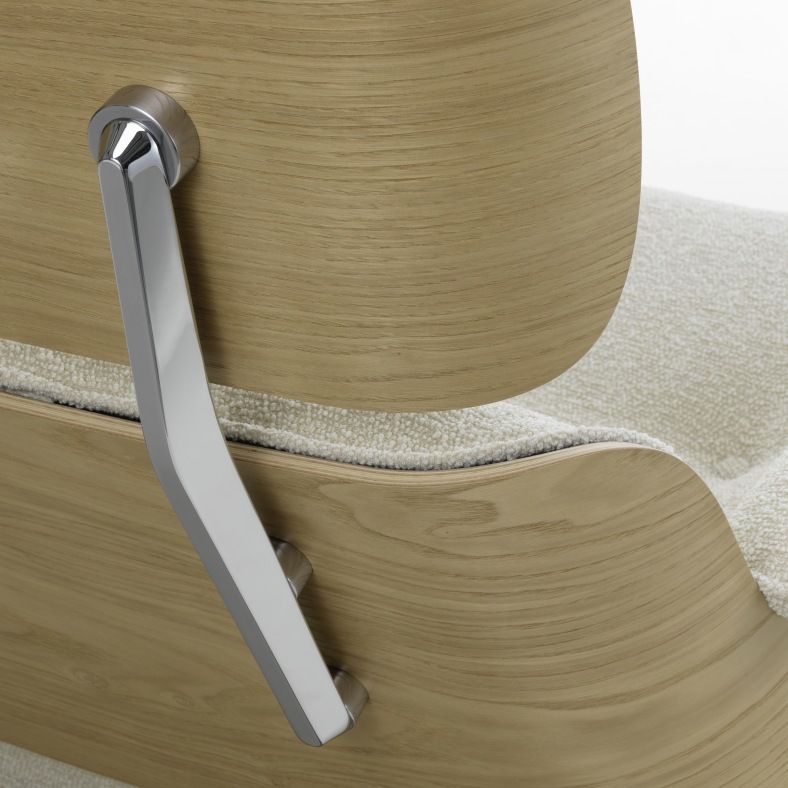 Detailaufnahme Eames Lounge Chair: Armlehne aus hellem Holz und cremefarbenem Stoffbezug, Designklassiker für Wohnzimmer.
