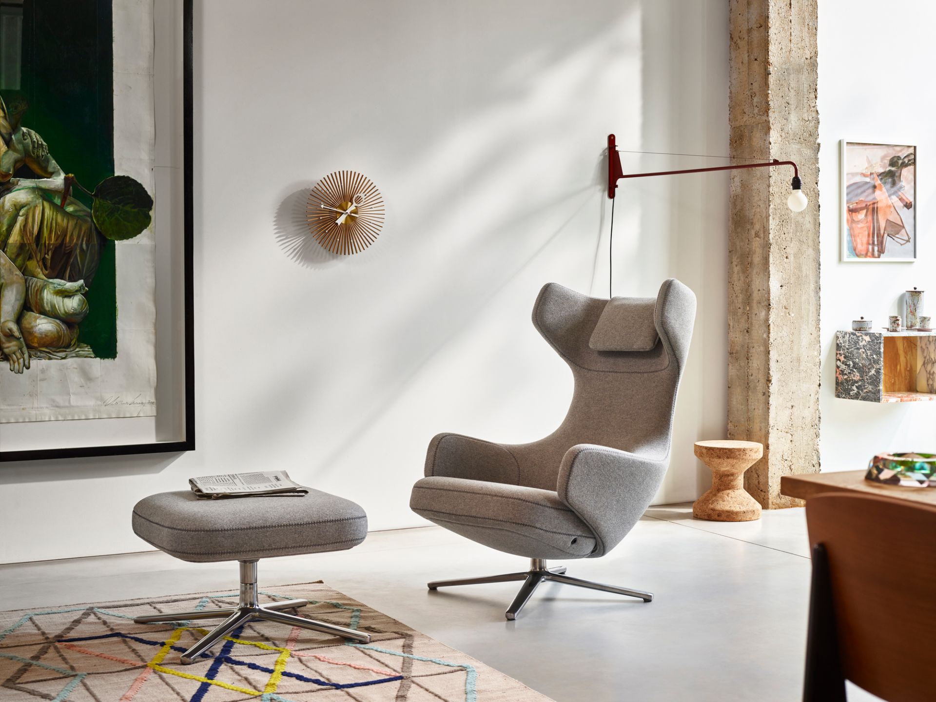Rote Petite Potence Wandleuchte von Vitra über einem grauen Sessel in modernem Wohnzimmer.