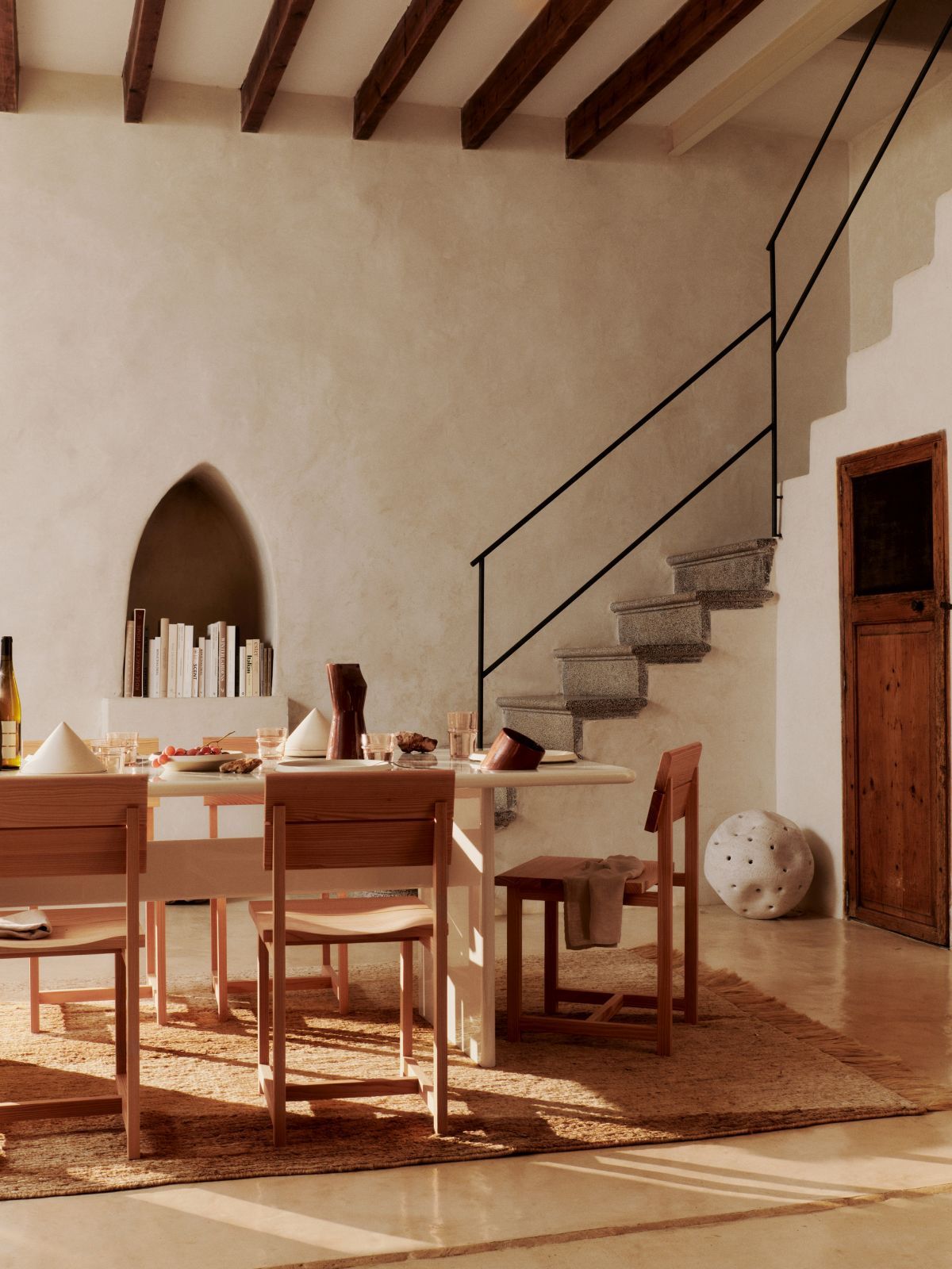 Visit Esszimmerstuhl von Ferm Living aus Holz an einem gedeckten Esstisch in modernem Ambiente.