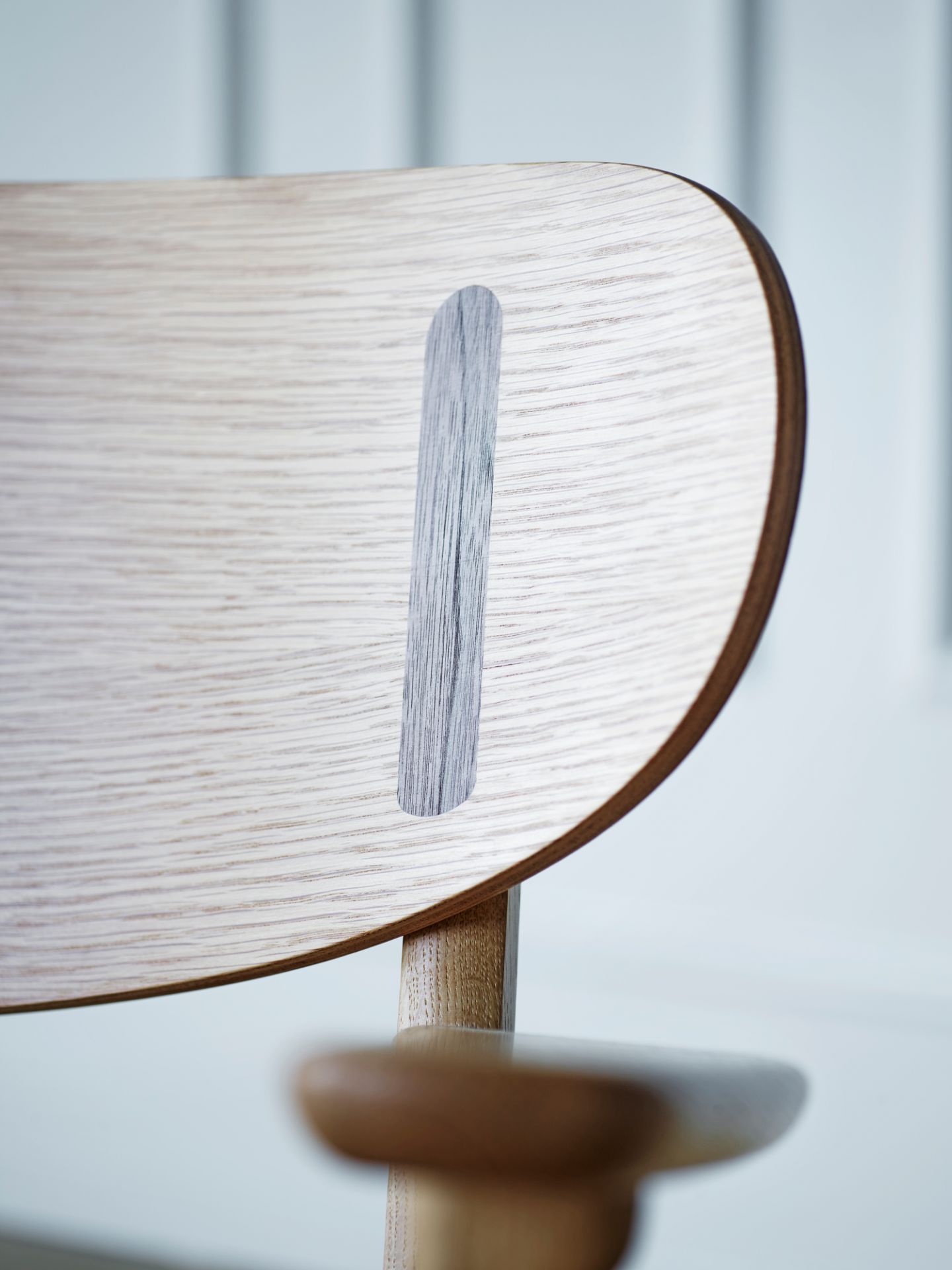 Detailaufnahme der Rückenlehne des CH26 Holzstuhls von Carl Hansen & Søn, helle Holzstruktur mit dunklem Akzent.