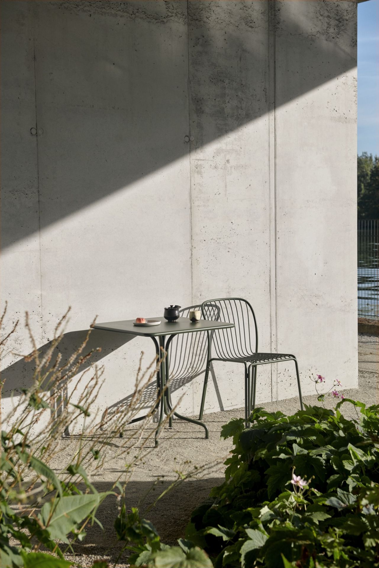 AndTradition Thorvald Gartentisch mit Stuhl im Außenbereich, modernes Design für Terrasse und Garten.