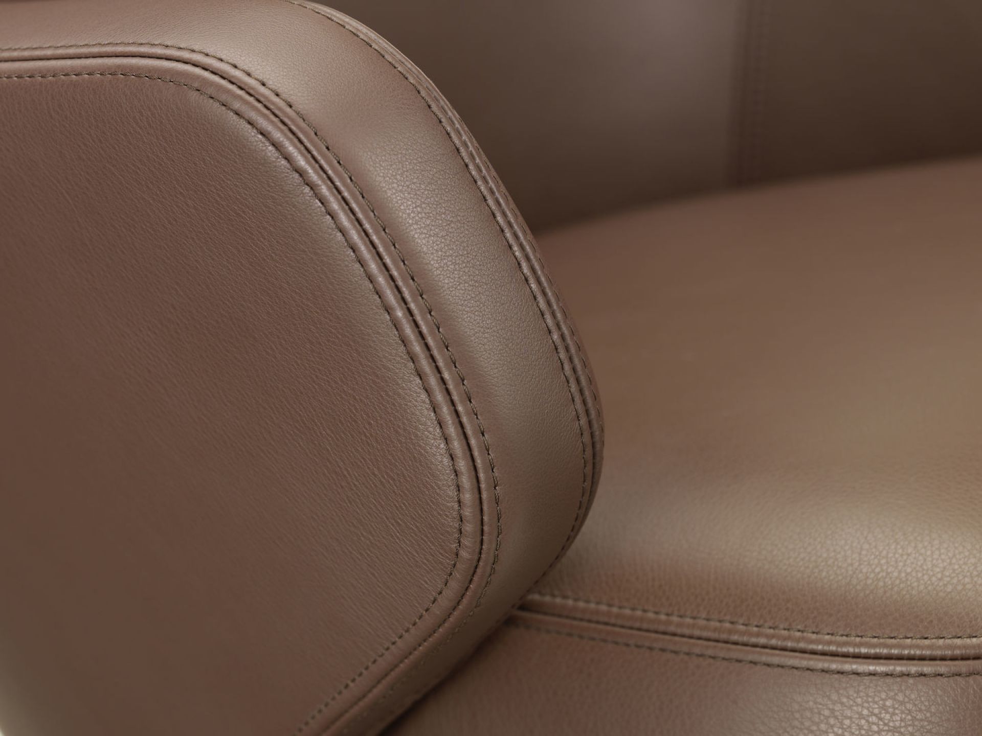 Detailaufnahme: Brauner Vitra Konferenzstuhl mit Lederbezug und feinen Ziernähten. Hochwertiger Bürostuhl für Konferenzräume.