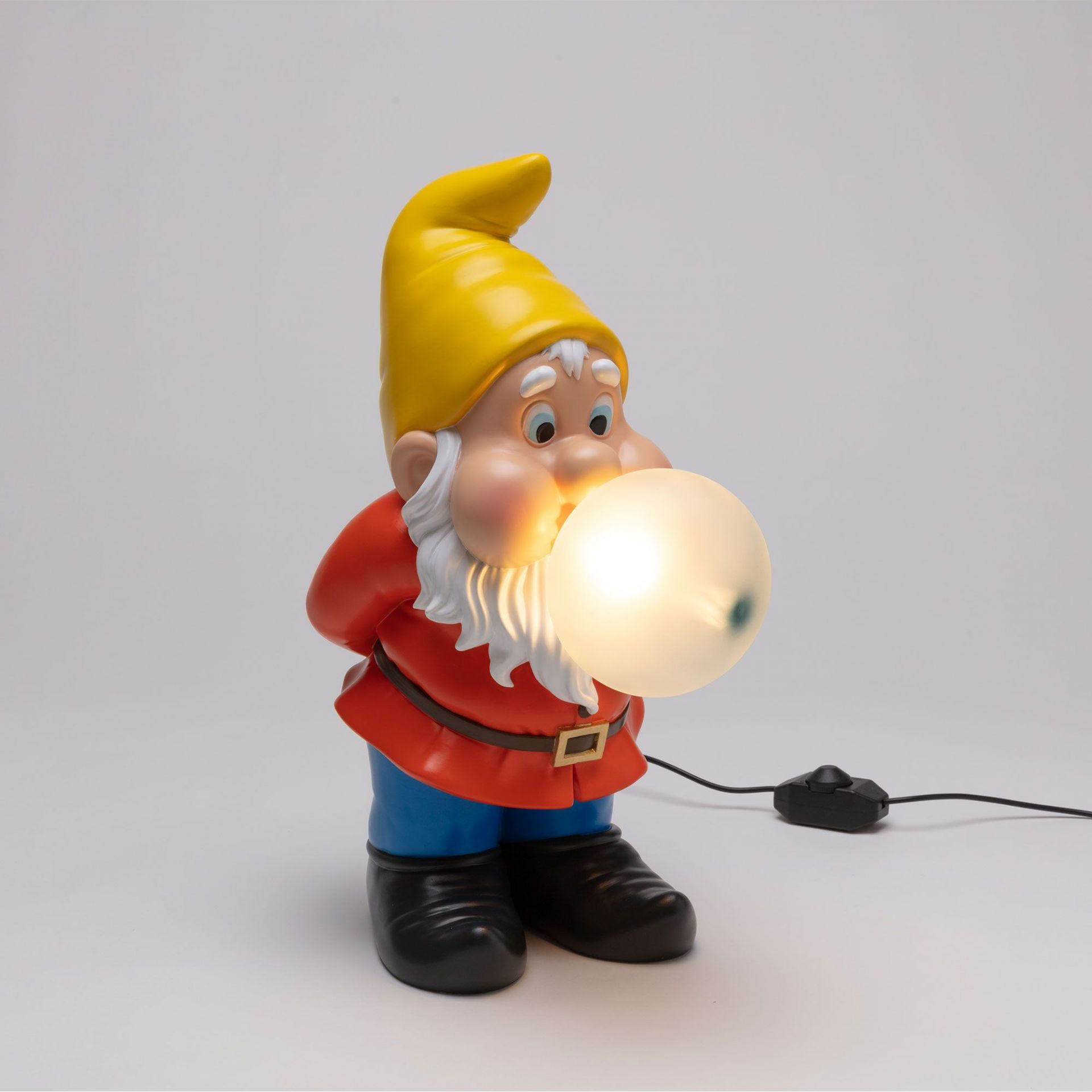 Gummy Snooping Lampe von Seletti: Detailaufnahme eines Gartenzwergs mit gelbem Hut und leuchtender Kaugummi-Blase.