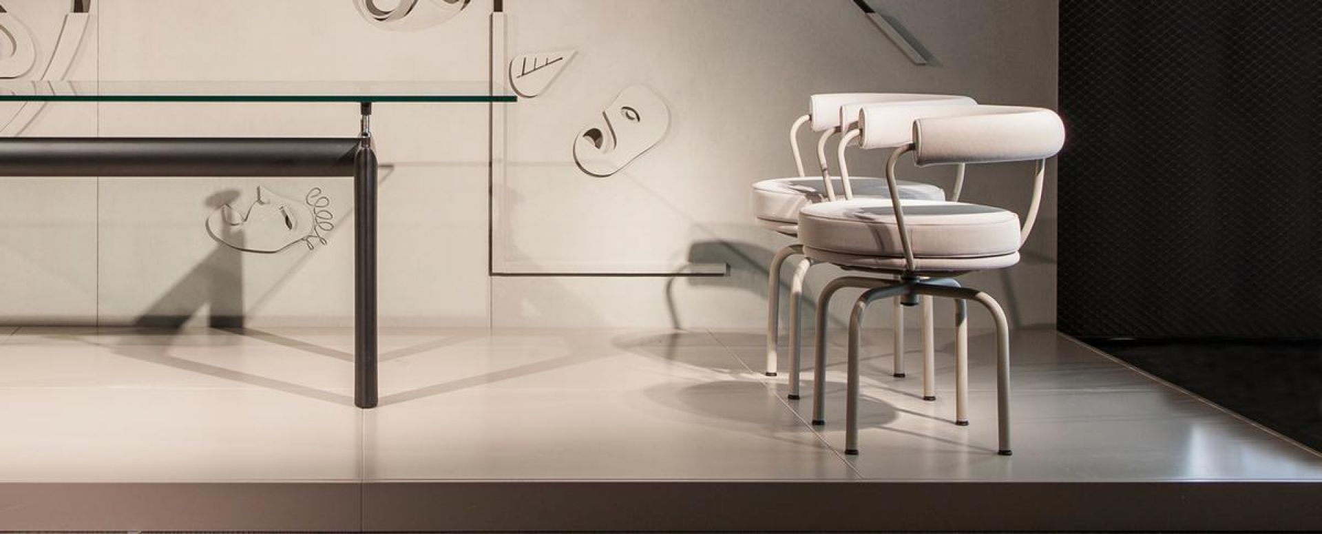 Zwei Cassina 7 Fauteuil Tournant Drehsessel in Weiß mit runden Sitzen und minimalistischem Design.