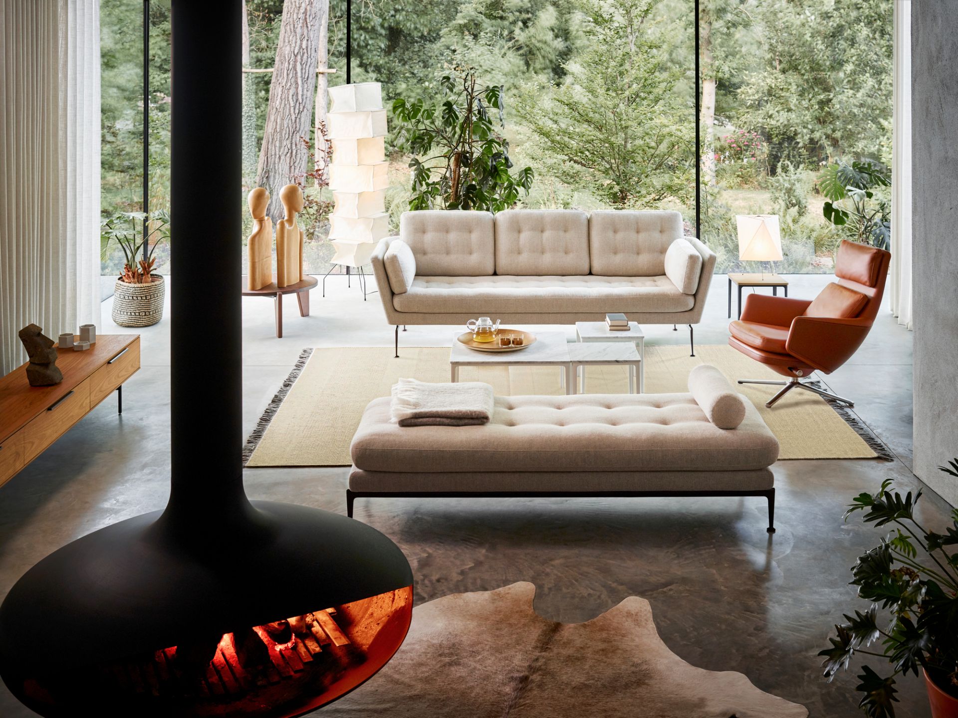 Innenaufnahme eines Wohnzimmers mit Vitra Grand Relax Sessel, Ottoman, Sofa und Kamin.