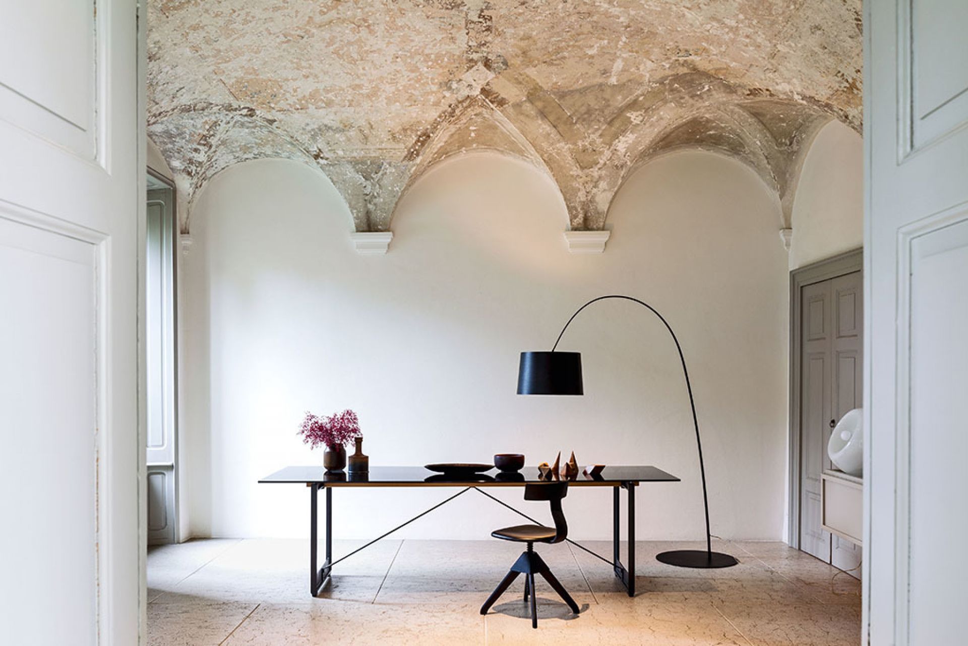Schwarzer Brut Tisch von Magis mit Stuhl und Bogenlampe in einem eleganten Interieur.