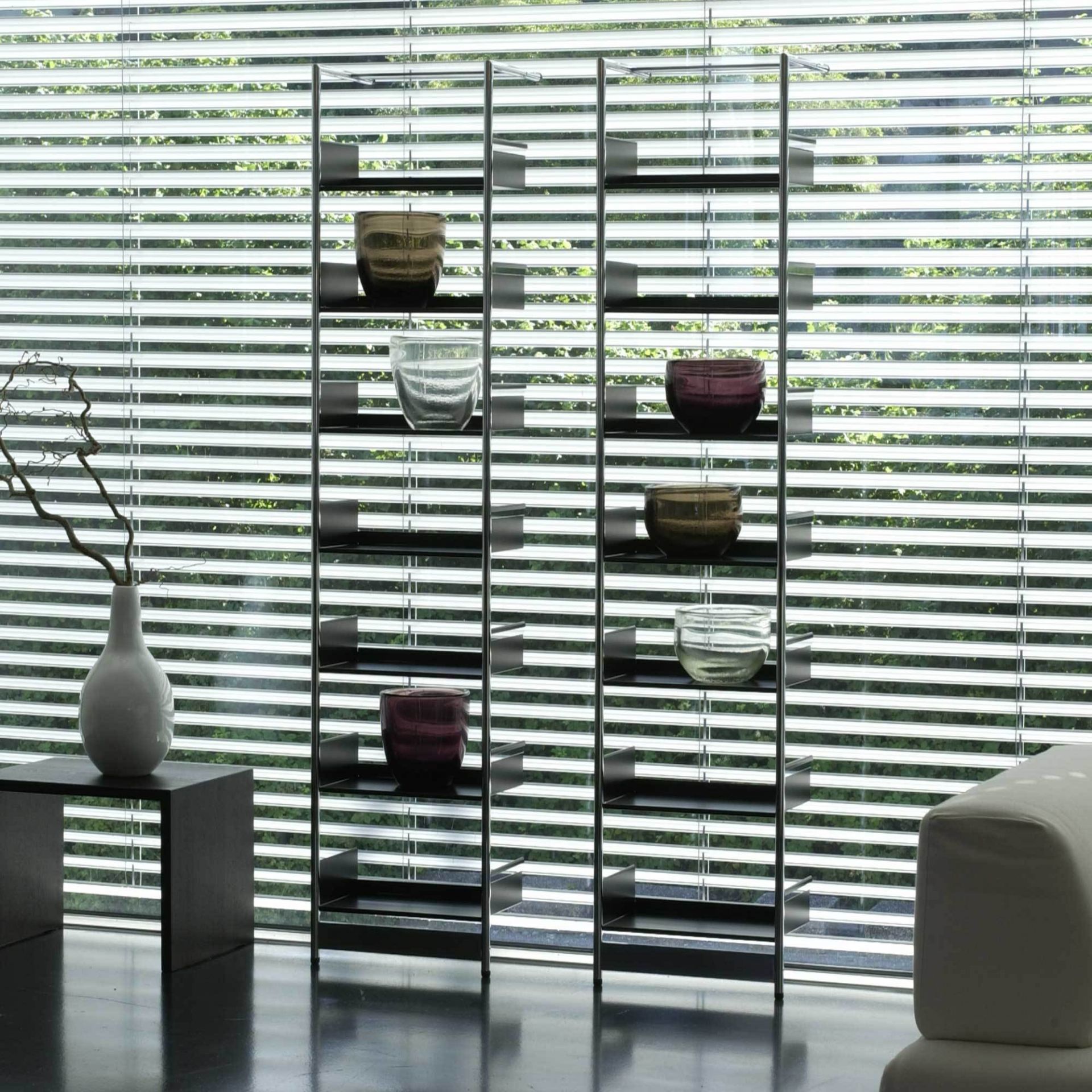 Mox Pool Anlehnregal 220/196 mit Verbindungstablaren, minimalistisches Design, Glasvasen auf Regalböden vor Fenster.