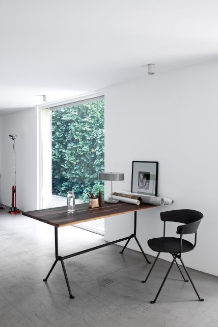 Schwarzer Officina Stuhl von Magis am Schreibtisch in einem hellen, modernen Büro mit großem Fenster.