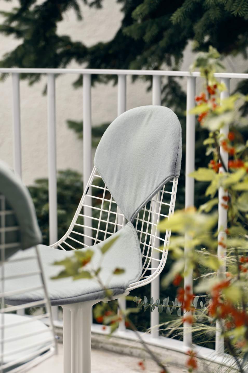 Vitra Wire Chair Bikini Outdoor, weißes Drahtgestell mit hellgrauem Sitz- und Rückenkissen, Gartenmöbel.
