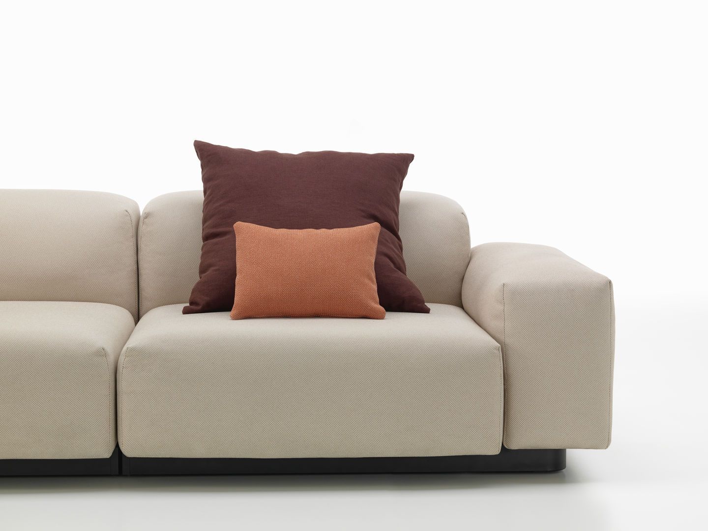 Vitra Kissen: Braunes und oranges Sofakissen auf einem beigen Sofa für Wohnzimmer oder Lounge.