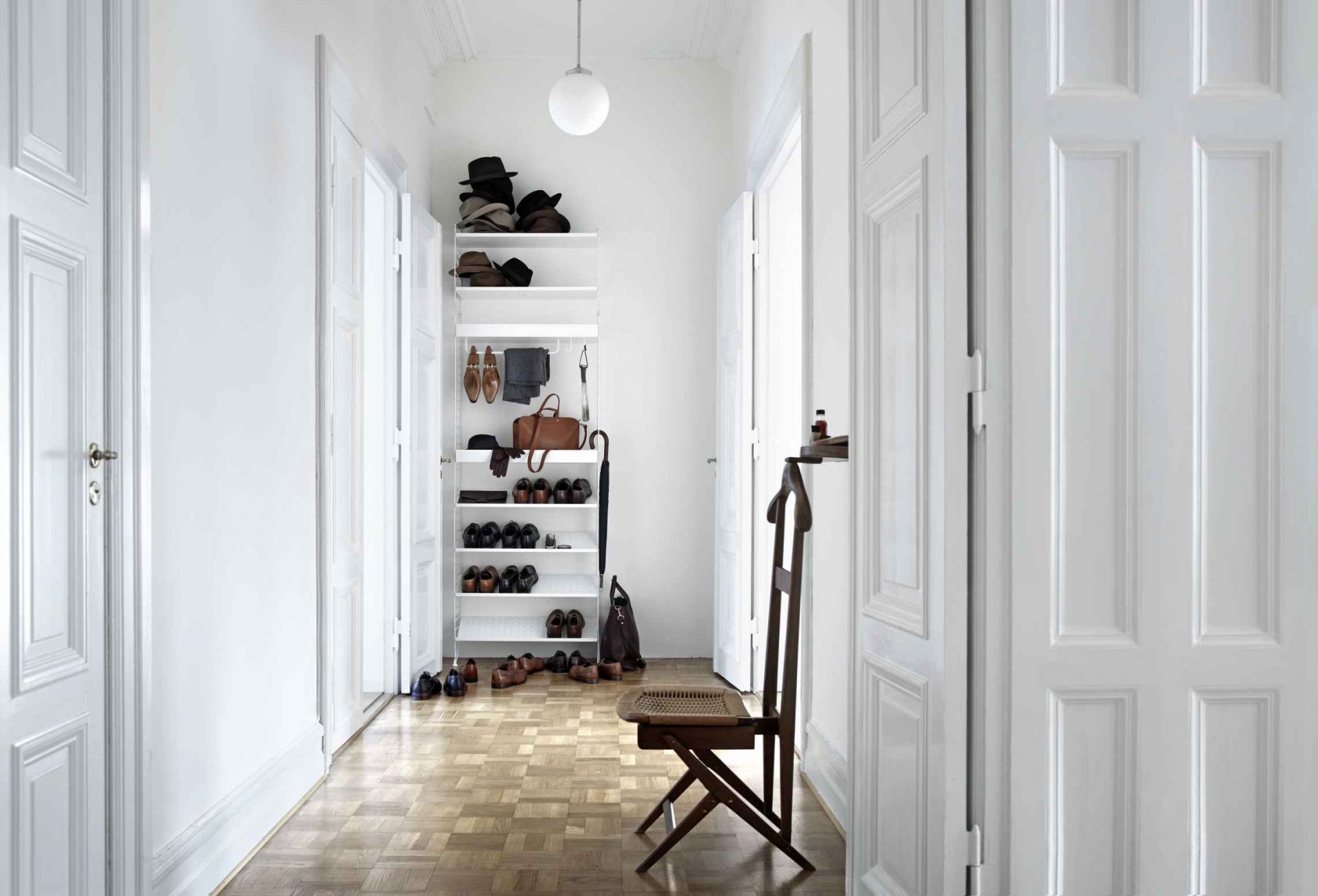 Beige String Regal im Flur mit Schuhen, Hüten und Accessoires. Skandinavisches Design.