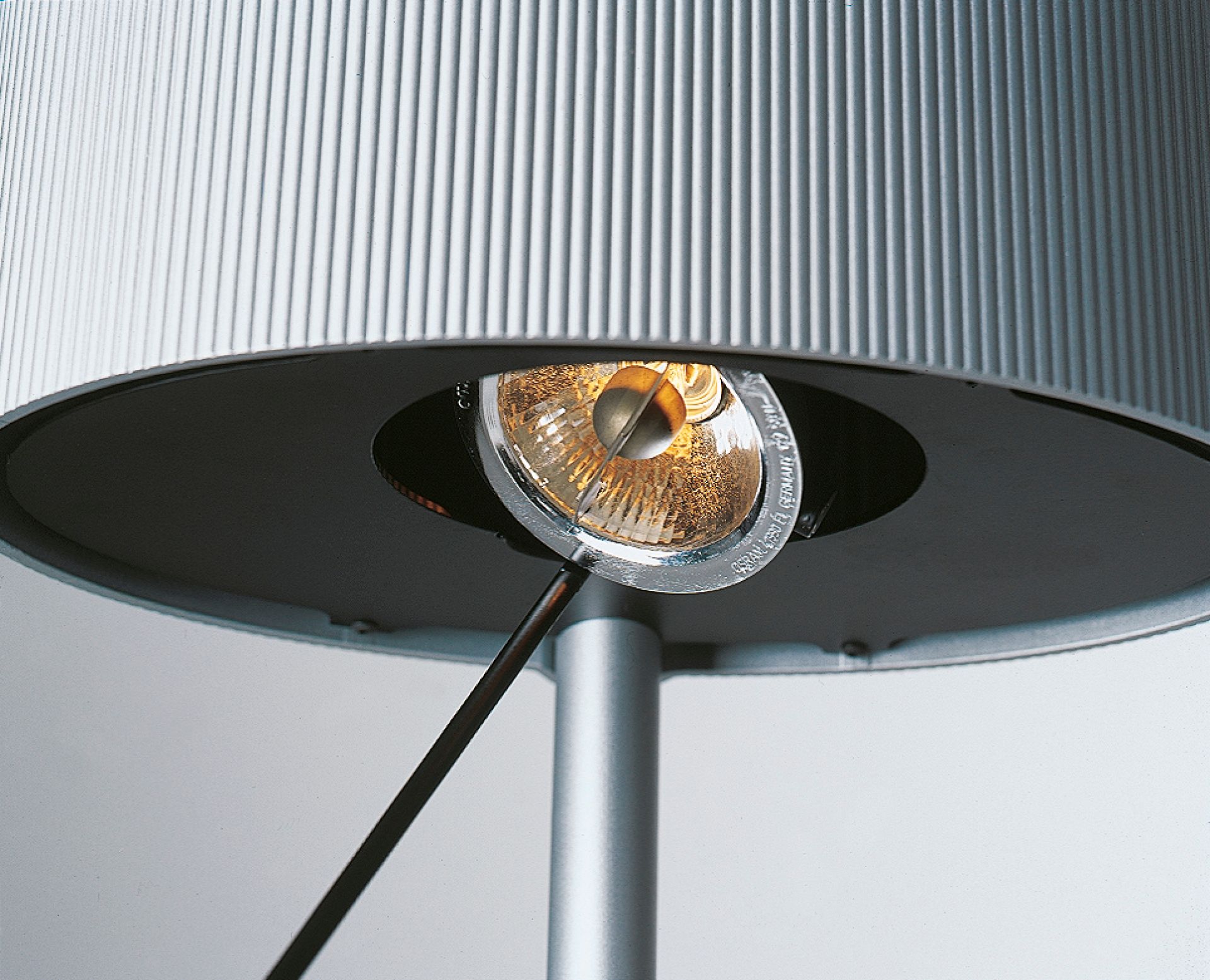 Detailaufnahme der Diogenes LED Stehleuchte von Belux mit geriffeltem Lampenschirm und warmem Lichtschein.