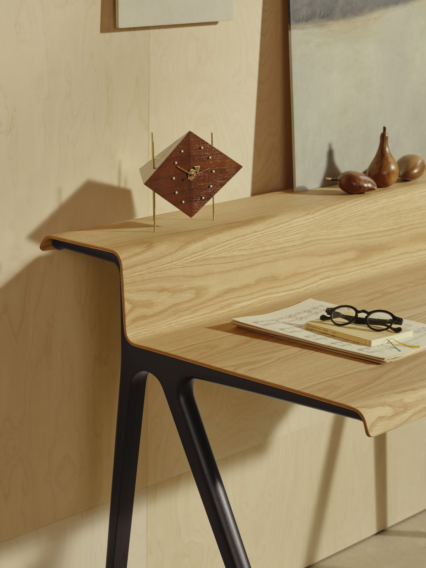 Detailaufnahme des Vitra Courier Schreibtischs mit Holzplatte und schwarzen Beinen, inklusive Accessoires.