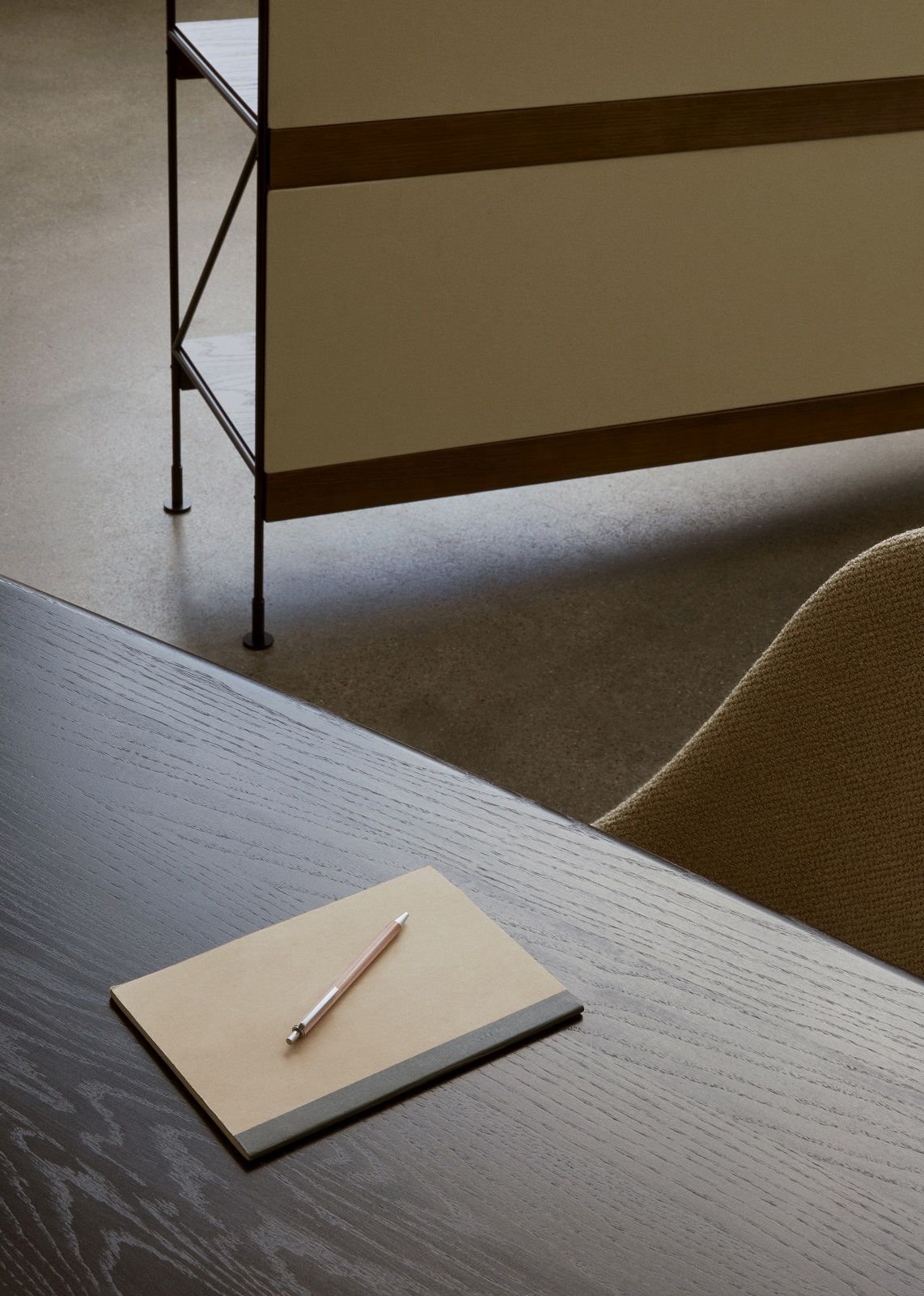 Detailaufnahme des Audo Copenhagen Zet Storage Regals H114 cm, kombiniert mit einem Schreibtisch und Notizblock.
