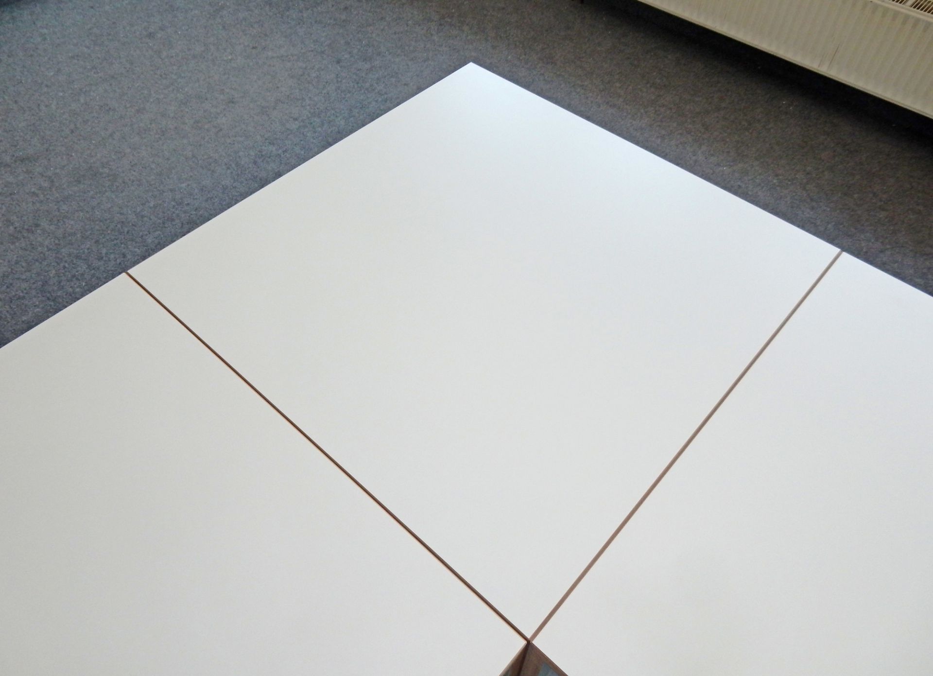 Detailansicht der weißen Tischplatte des Tojo Freistell Tisch klein, minimalistisches Design.