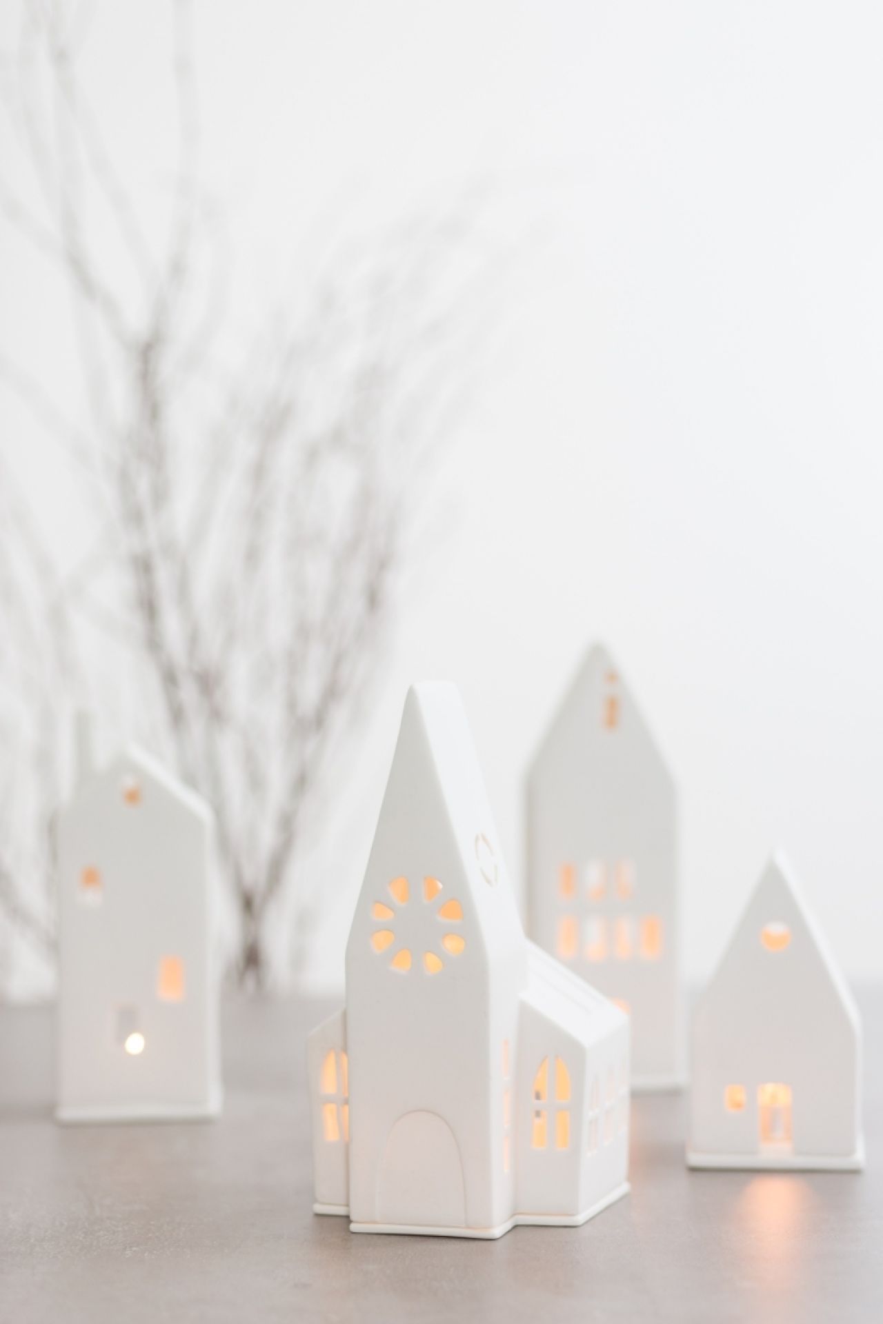 Detailaufnahme von weißen Lichthäusern, darunter eine Kirche, für stimmungsvolle Weihnachtsdekoration.