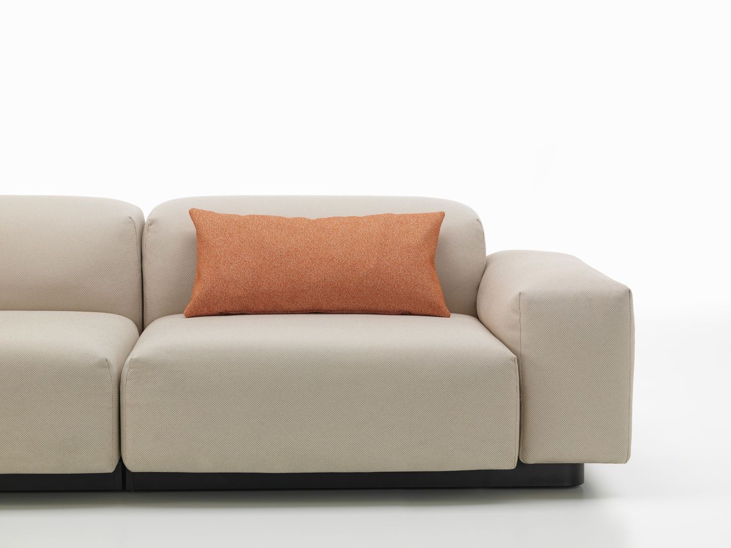 Vitra Kissen: Rechteckiges, orangefarbenes Sofakissen auf einem hellen modularen Sofa, modernes Wohnaccessoire für stilvolles Wohnen.
