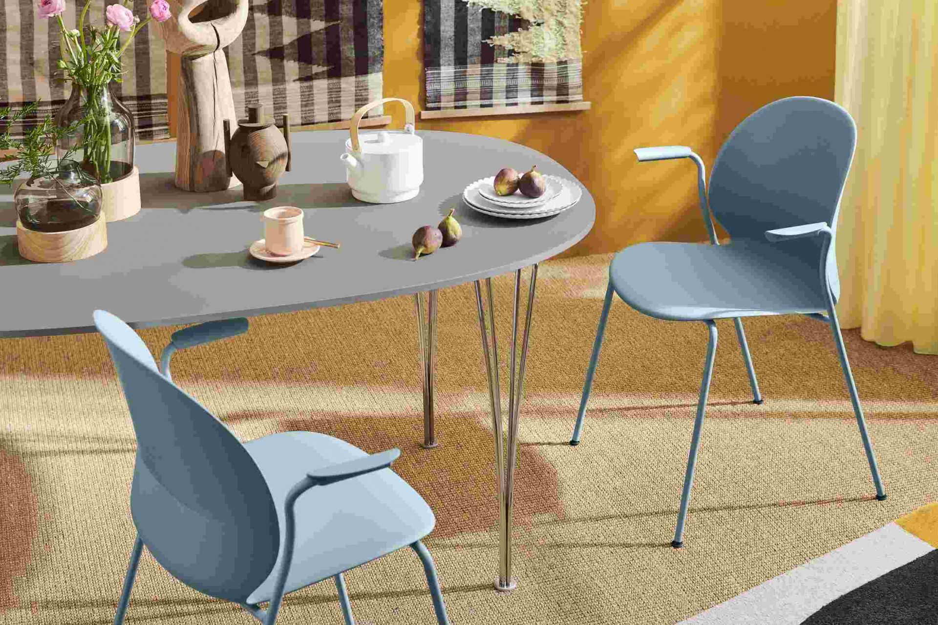 Fritz Hansen Super Elliptisch Tisch mit Teekanne, Geschirr und blauen Stühlen in einem modernem Esszimmer.
