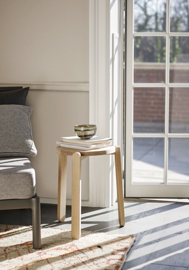 Nomad Stool Hocker von Skagerak: Hocker aus hellem Holz mit Büchern und Schale.