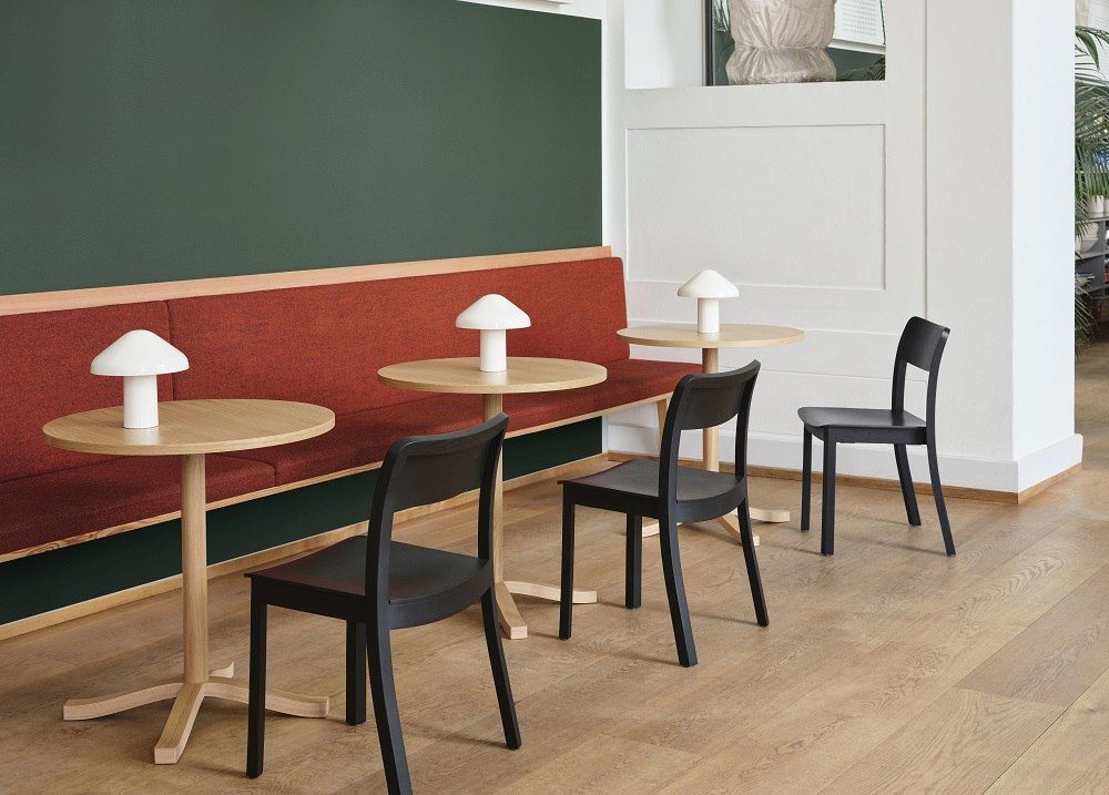 Helle Holztische und schwarze Stühle von Hay, Pastis Table, mit Pilzlampen in modernem Café.