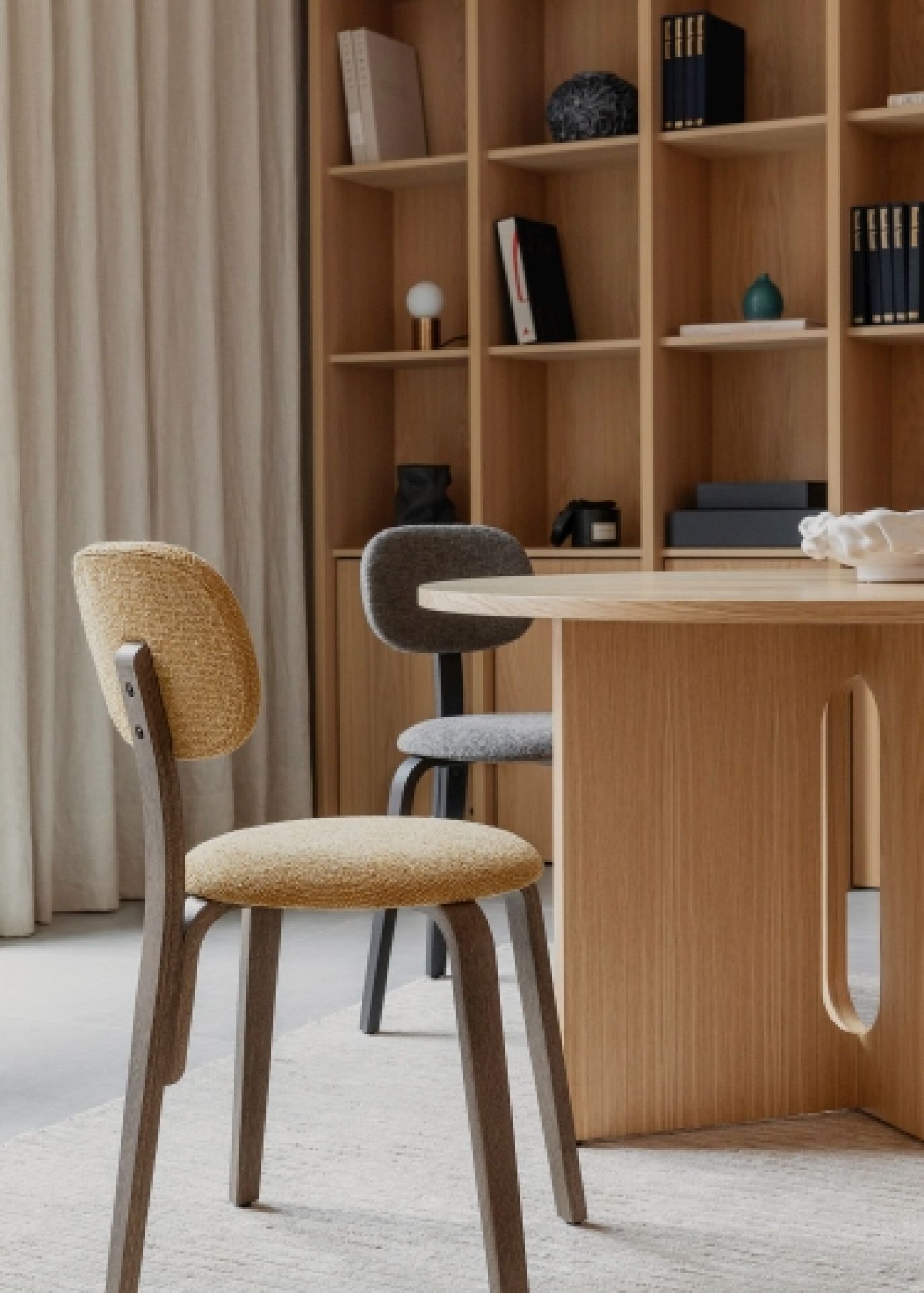 Androgyne Esstisch aus Eiche dunkel gebeizt mit Sandstein-Oberfläche, kombiniert mit Stühlen in einem modernen Esszimmer.