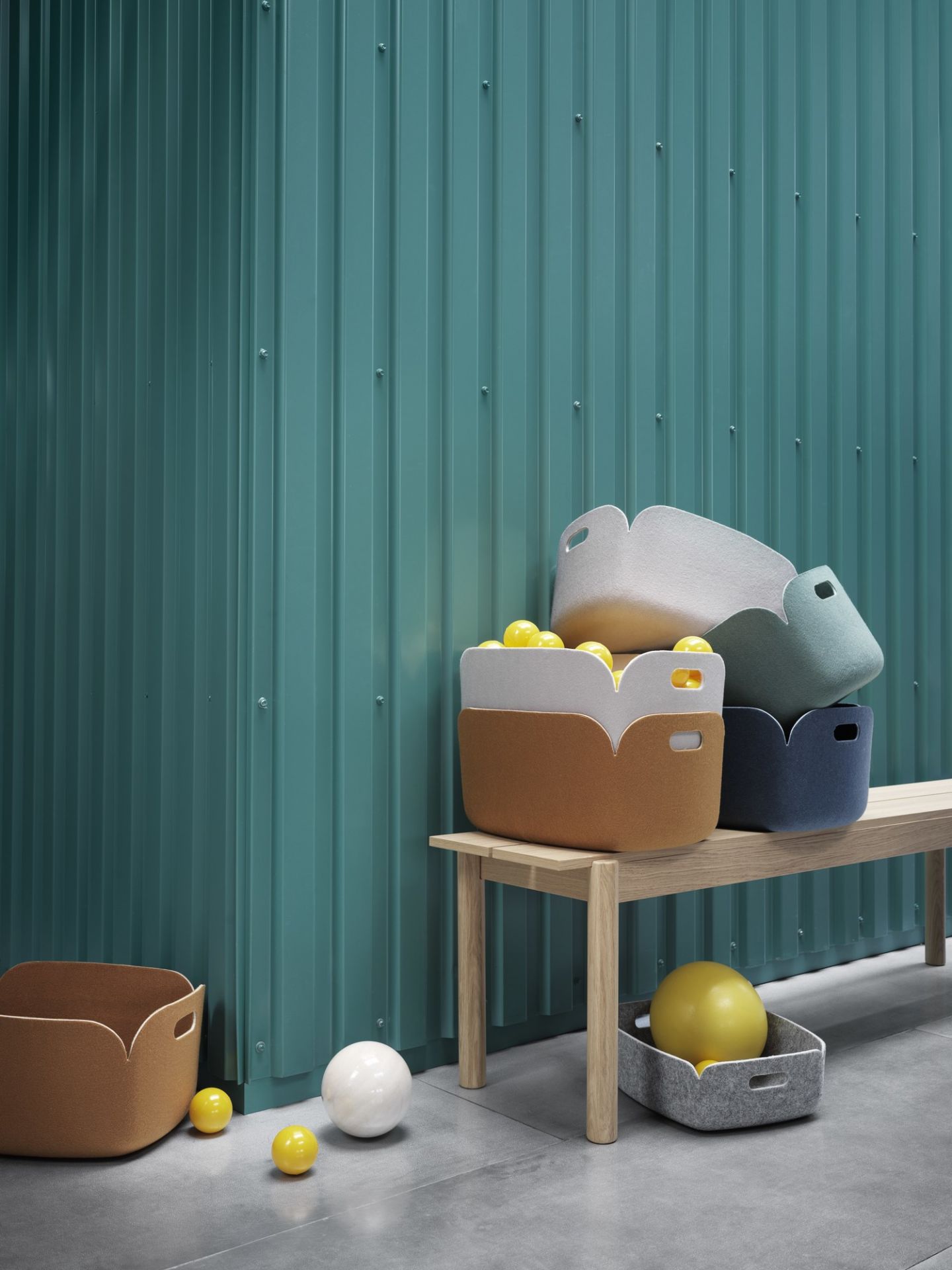 Muuto Restore Storage Basket in Mitternachtsblau und anderen Farben auf Holzbank. Aufbewahrungskorb aus Filz.