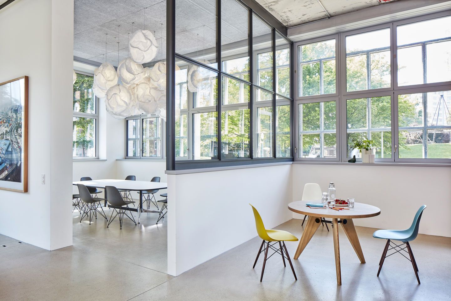 Innenaufnahme eines Büros mit Vitra Eames Fiberglass Chairs DSW und einem Tisch mit Holzbeinen.