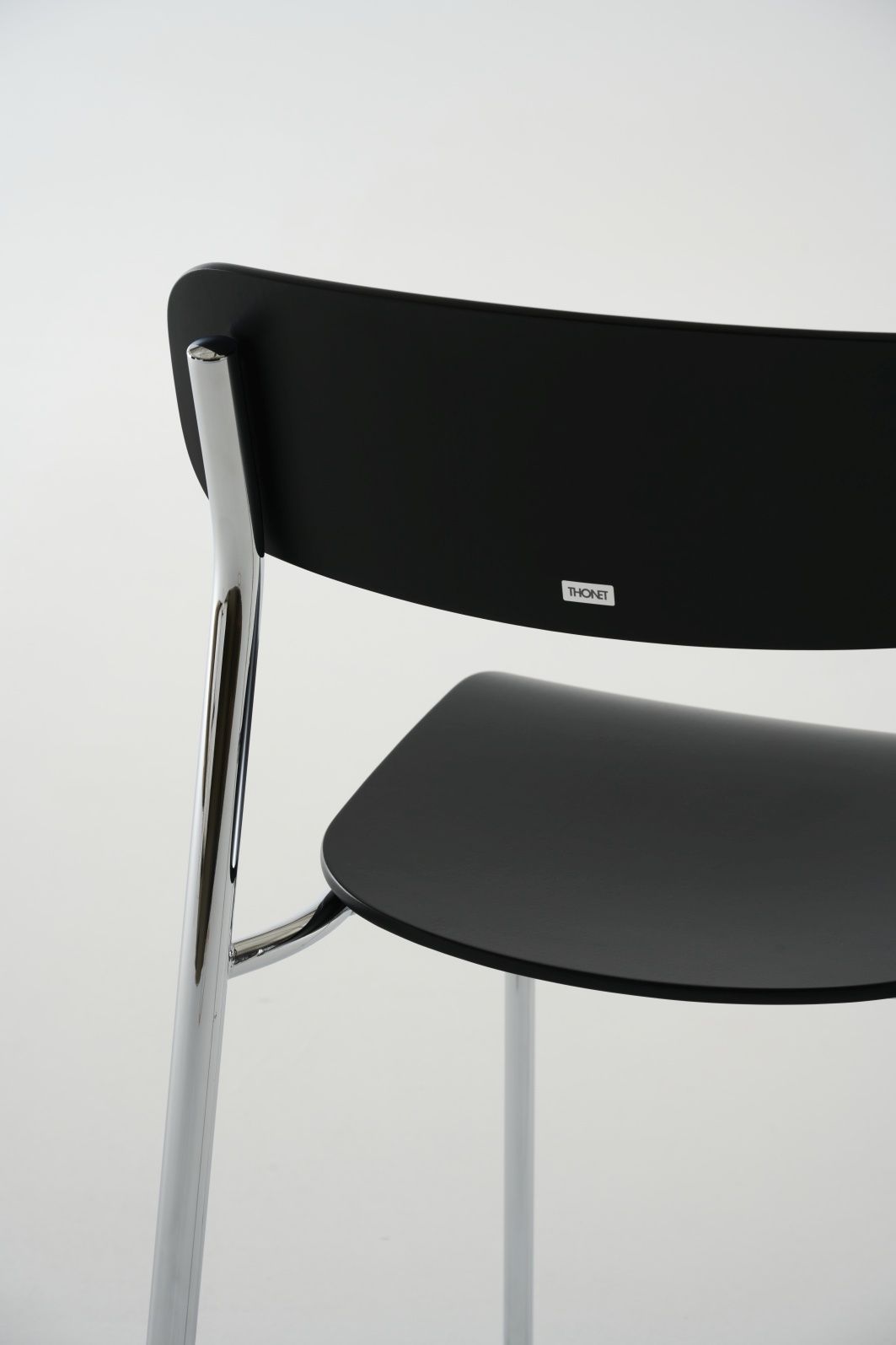Detailaufnahme von Thonet S 243 Stahlrohrstuhl mit schwarzer Sitzfläche und Rückenlehne, verchromtem Stahlrohrgestell.